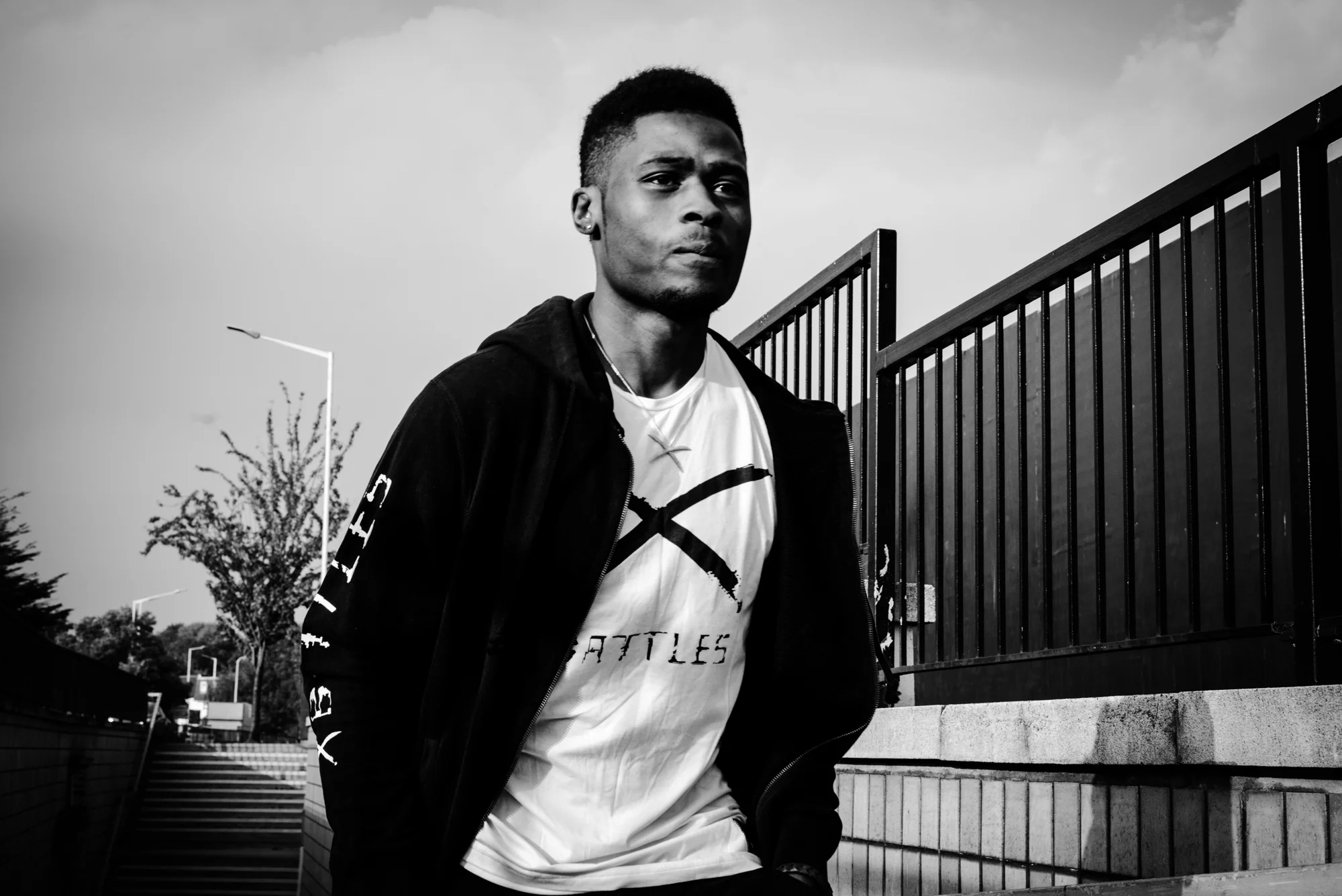 Josh wears zip-up hoodie and white T-shirt by Battles of London