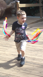 A Play Days explorer dances to the beat with colorful scarves.