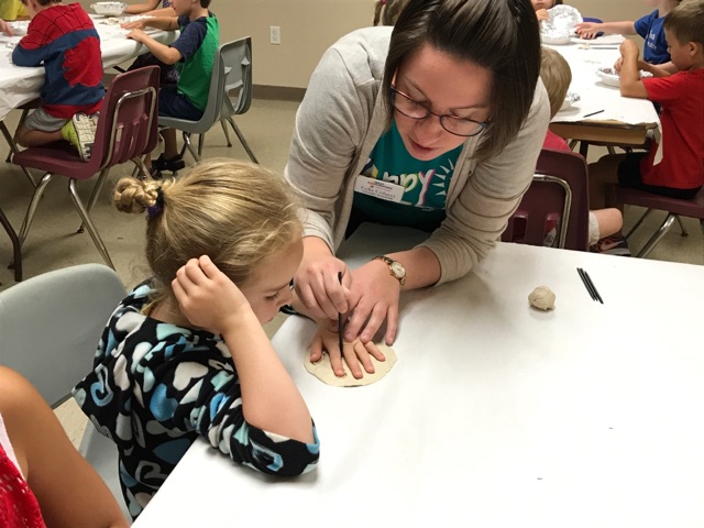Some children needed help to trace their hands in the clay