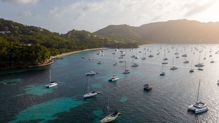 Sailboats anchored in a Caribbean bay at golden hour