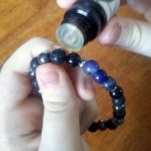 adding oil to lava stone diffuser bracelet.jpg