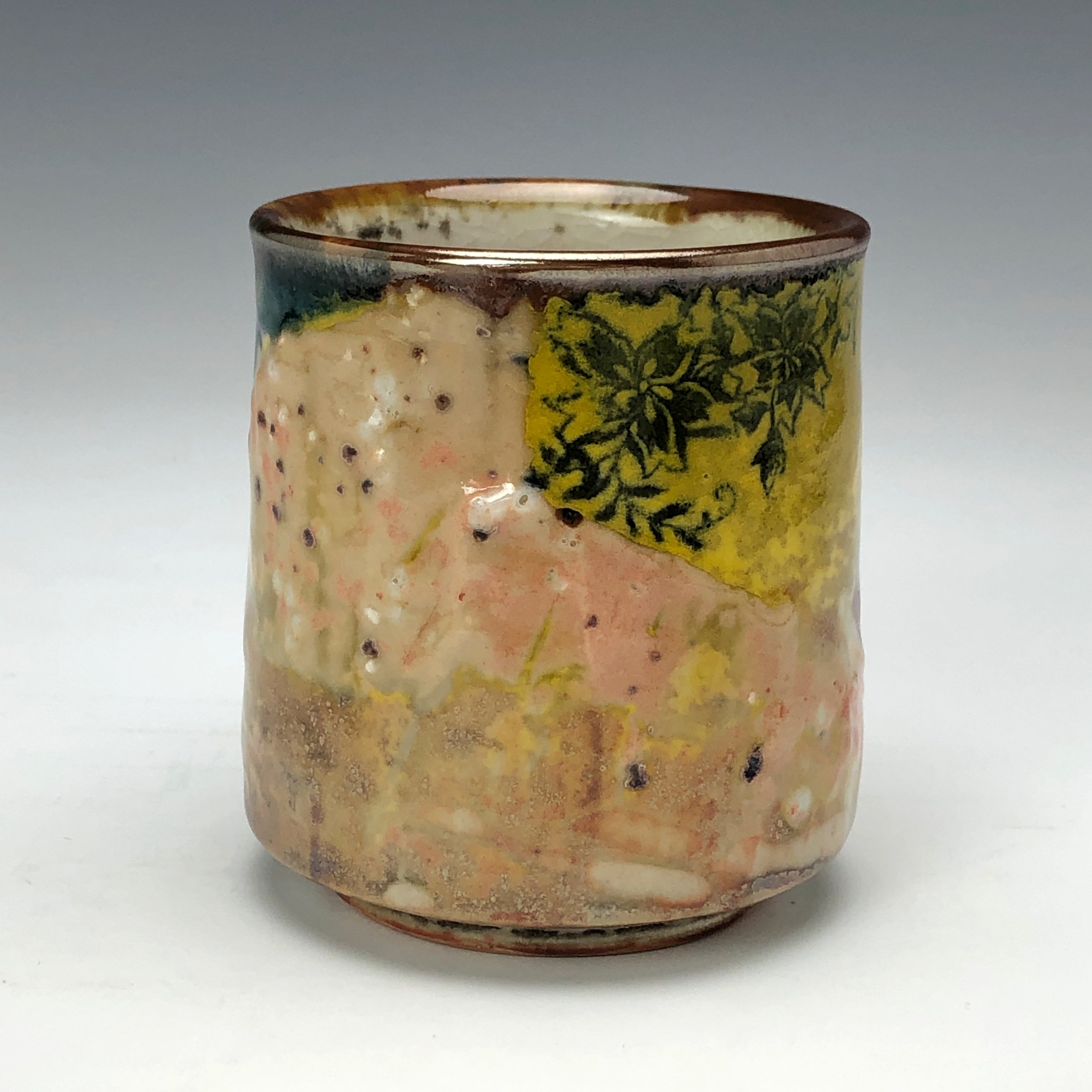  Bruce Gholson, Bulldog Pottery, Seagrove, North Carolina   Yunomi 1  - Casual drinking cup made from porcelain with Iron Luster Fish. Ceramic cup also has swipes of yellow and blue with a cobalt blue transfer. A textural shino is also glazed onto th