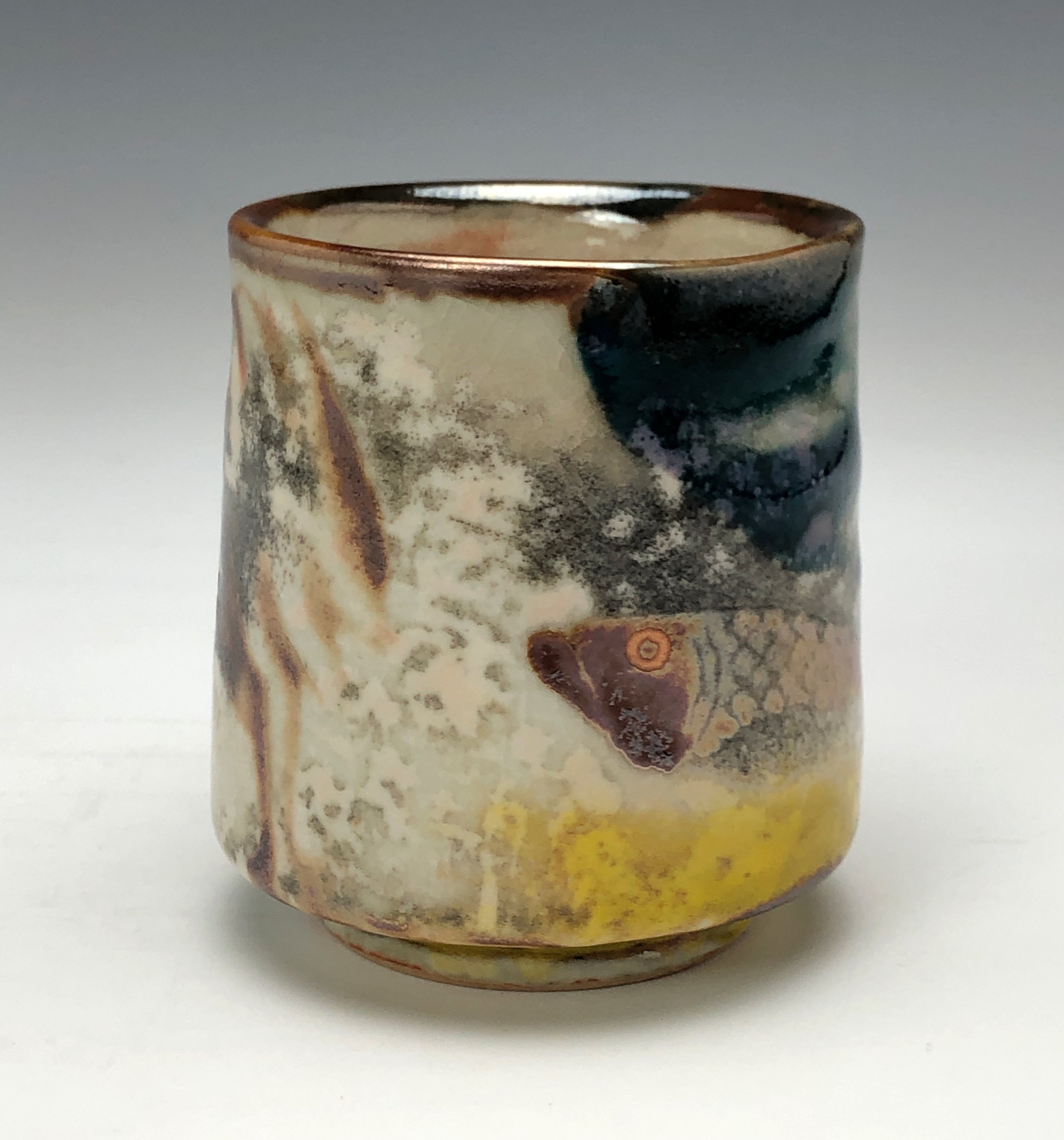  Bruce Gholson, Bulldog Pottery, Seagrove, North Carolina   Yunomi 2  - Casual drinking cup made from porcelain with Iron Luster Fish. Ceramic cup also has swipes of yellow and blue. A textural shino is also glazed onto the some areas of the cup’s su