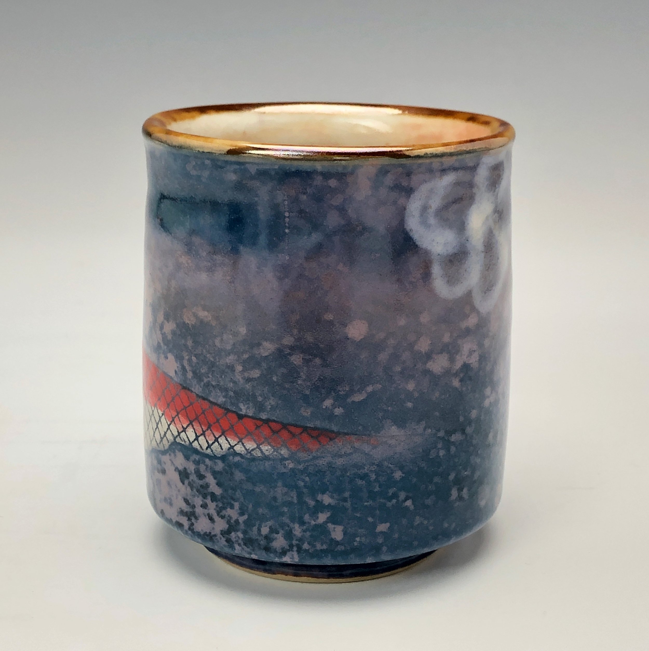  Bruce Gholson, Bulldog Pottery, Seagrove, North Carolina  Yunomi 4- Casual drinking cup made from porcelain. This cup is glazed with a lavender blue shino with a drawn fish in red over glaze. 