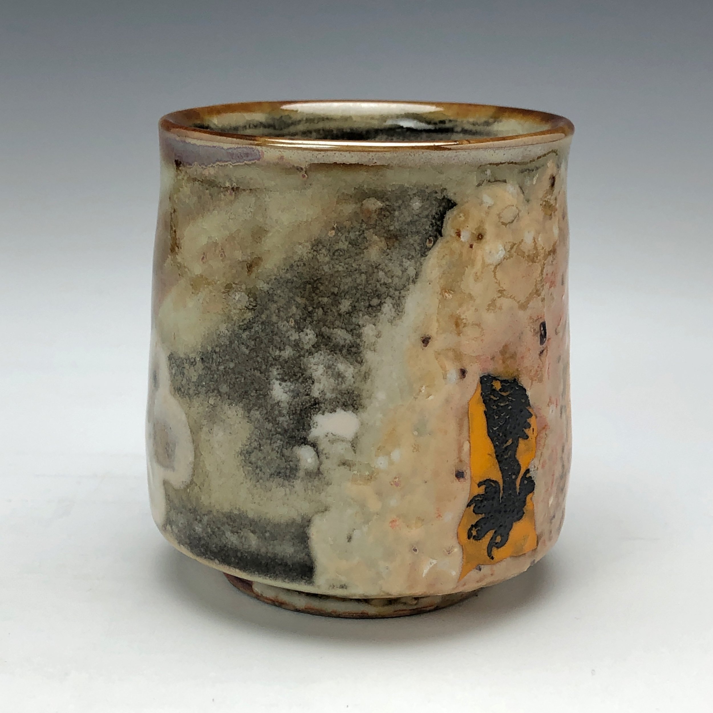  Bruce Gholson, Bulldog Pottery, Seagrove, North Carolina   Yunomi 5  - Casual drinking cup made from porcelain with Iron Luster Fish. Ceramic cup also has swipes of yellow and blue. A textural shino is also glazed onto the some areas of the cup’s su