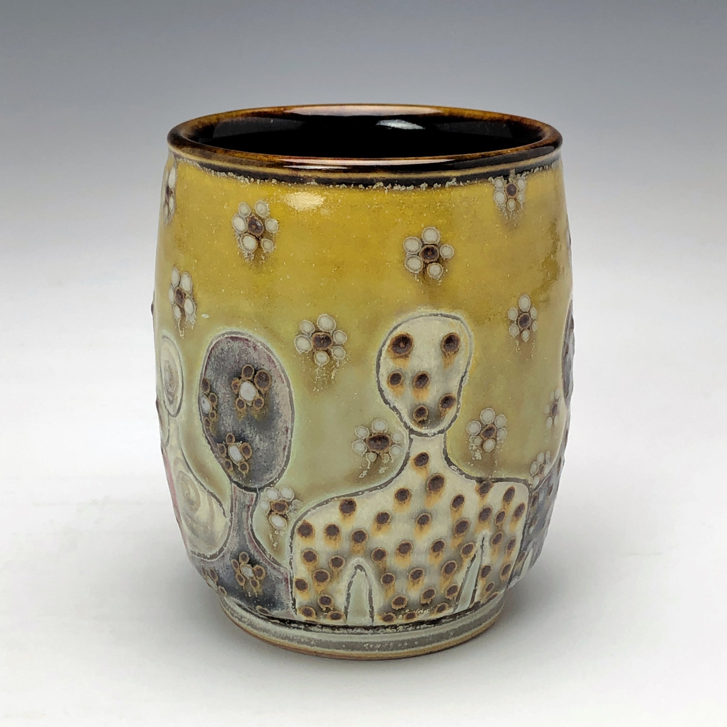  Samantha Henneke, Bulldog Pottery, Seagrove, North Carolina  Yunomi 1- Casual drinking cup made from a smooth white porcelaneous clay body. Figurative decoration with slip and glaze dot patterns. Translucent vellum glaze over various underglaze colo