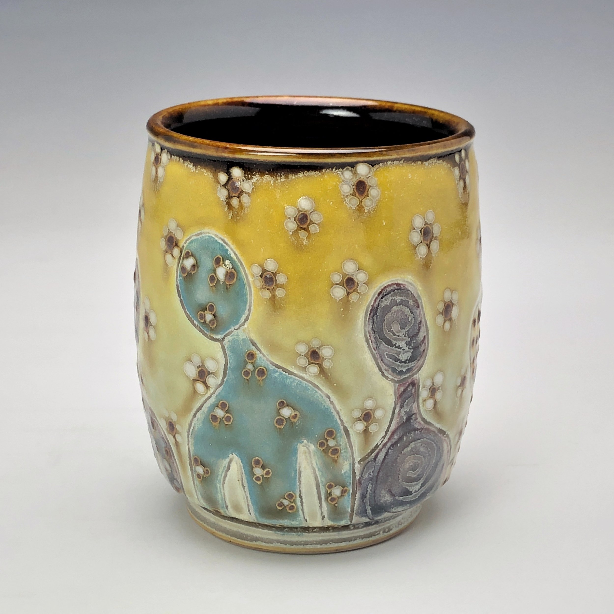  Samantha Henneke, Bulldog Pottery, Seagrove, North Carolina  Yunomi 1- Casual drinking cup made from a smooth white porcelaneous clay body. Figurative decoration with slip and glaze dot patterns. Translucent vellum glaze over various underglaze colo