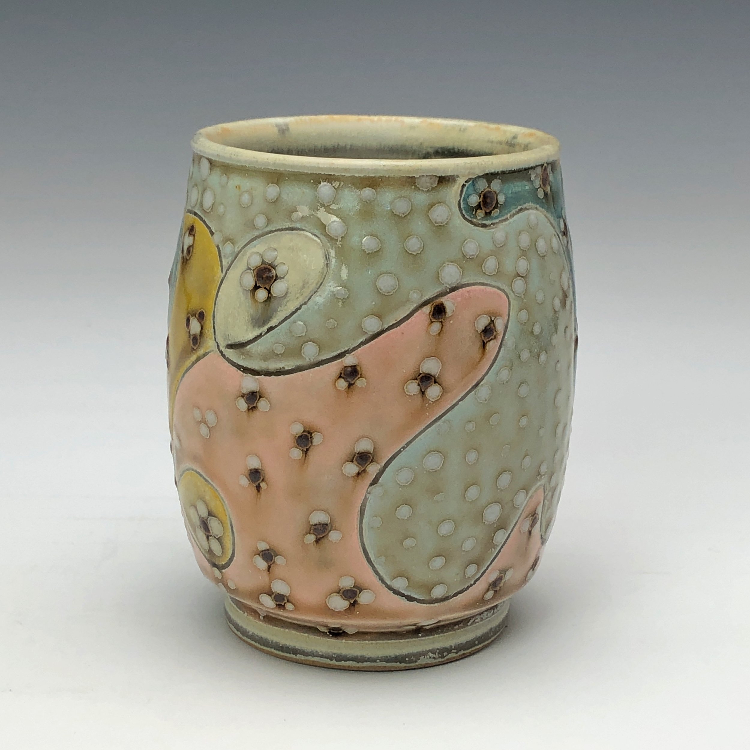  Samantha Henneke, Bulldog Pottery, Seagrove, North Carolina  Yunomi 2- Casual drinking cup made from a smooth white porcelaneous clay body. Pattern Medley patterns are made with slip and glaze dot patterns. Translucent vellum glaze over various unde