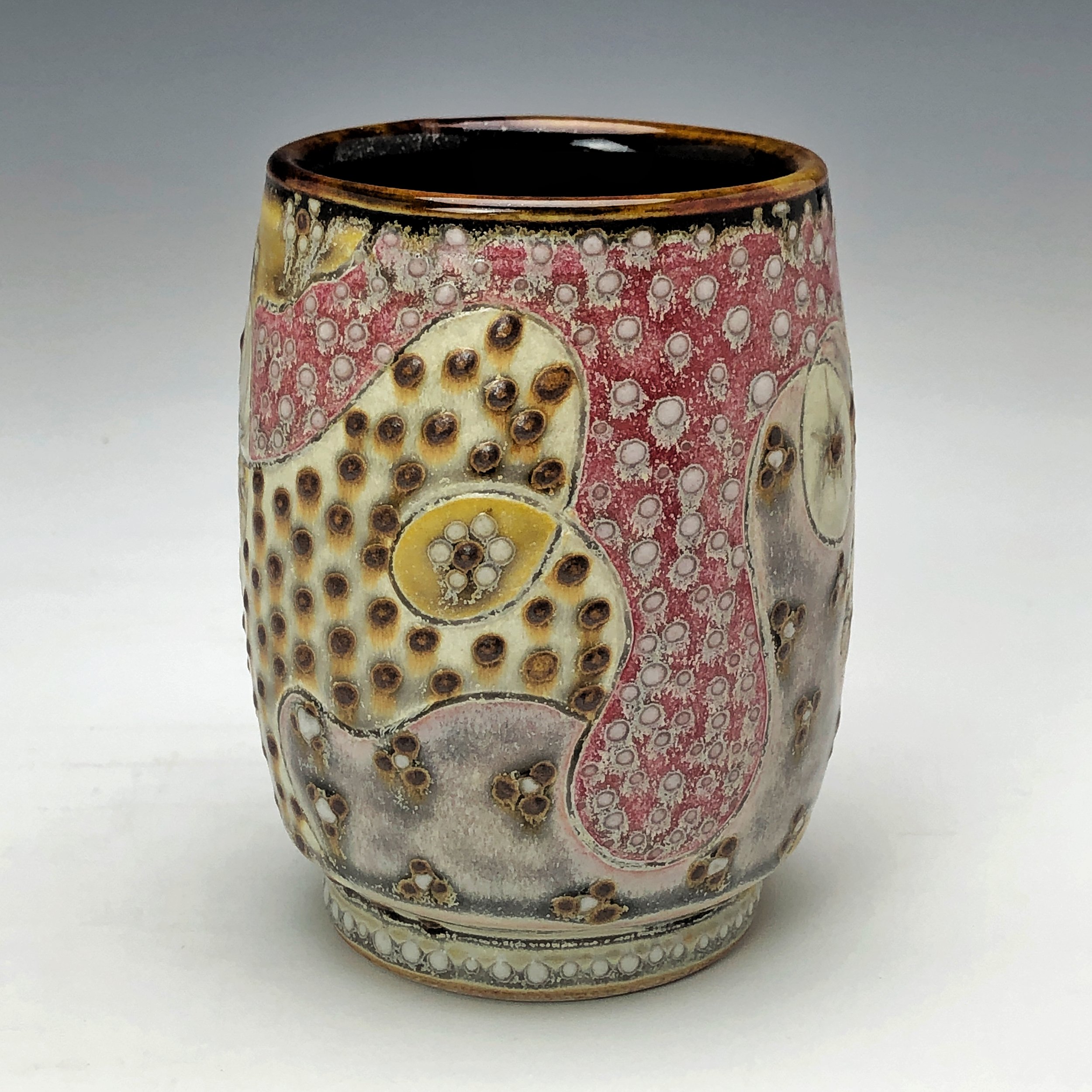  Samantha Henneke, Bulldog Pottery, Seagrove, North Carolina  Yunomi 3- Casual drinking cup made from a smooth white porcelaneous clay body. Pattern Medley patterns are made with slip and glaze dot patterns. Translucent vellum glaze over various unde