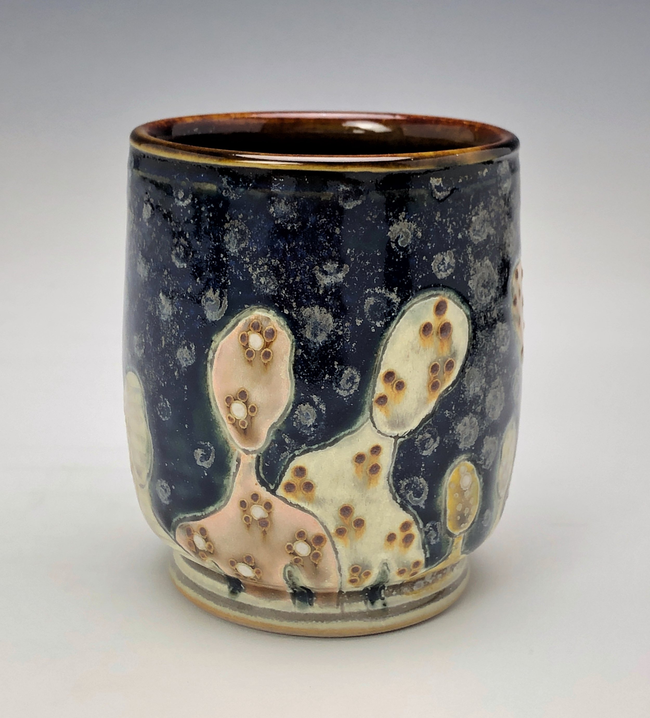  Samantha Henneke, Bulldog Pottery, Seagrove, North Carolina  Yunomi 4- Casual drinking cup made from a smooth white porcelaneous clay body. Figurative decoration with slip and glaze dot patterns. Translucent vellum glaze over various underglaze colo