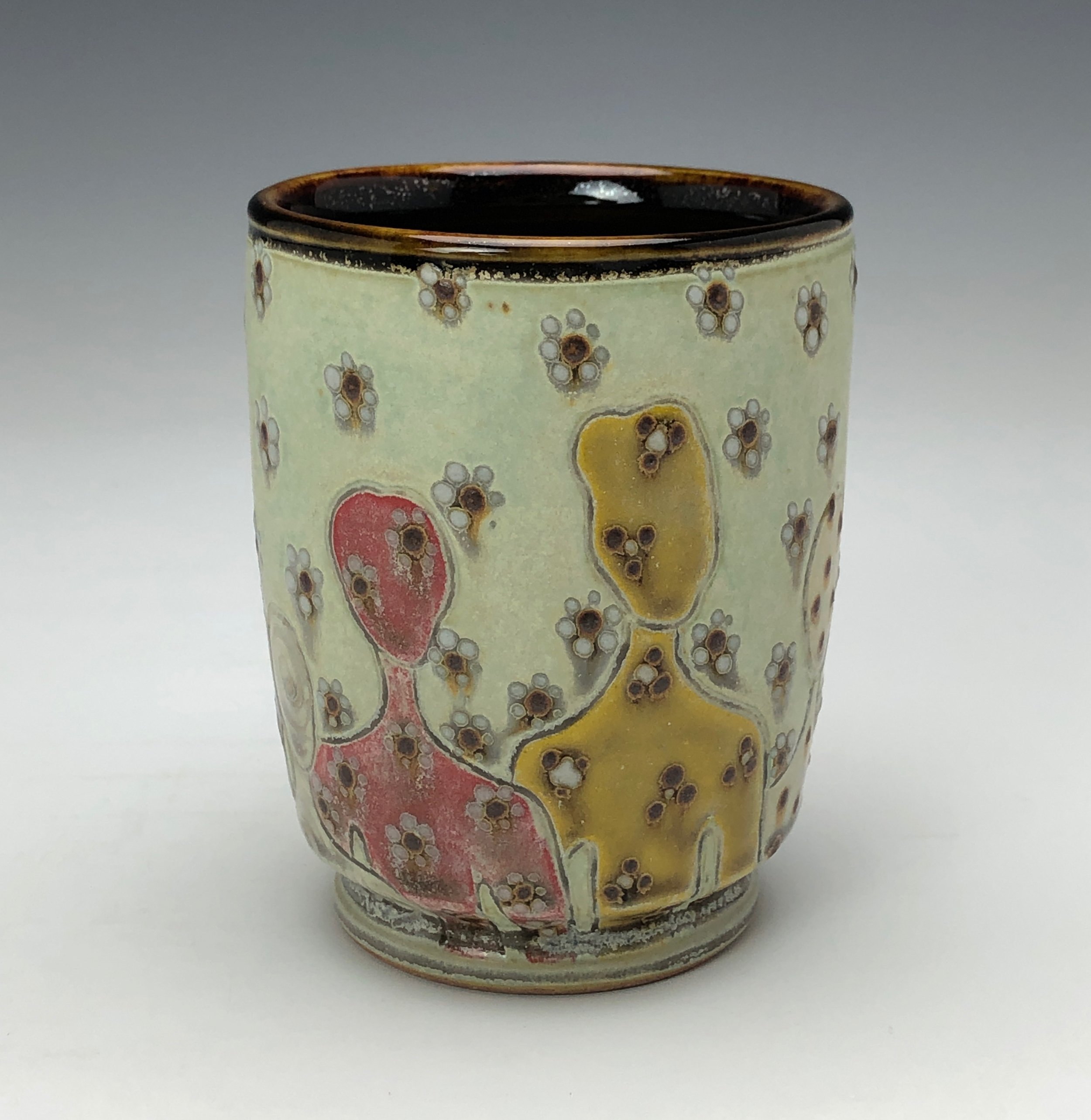  Samantha Henneke, Bulldog Pottery, Seagrove, North Carolina  Yunomi 6- Casual drinking cup made from a smooth white porcelaneous clay body. Figurative decoration with slip and glaze dot patterns. Translucent vellum glaze over various underglaze colo