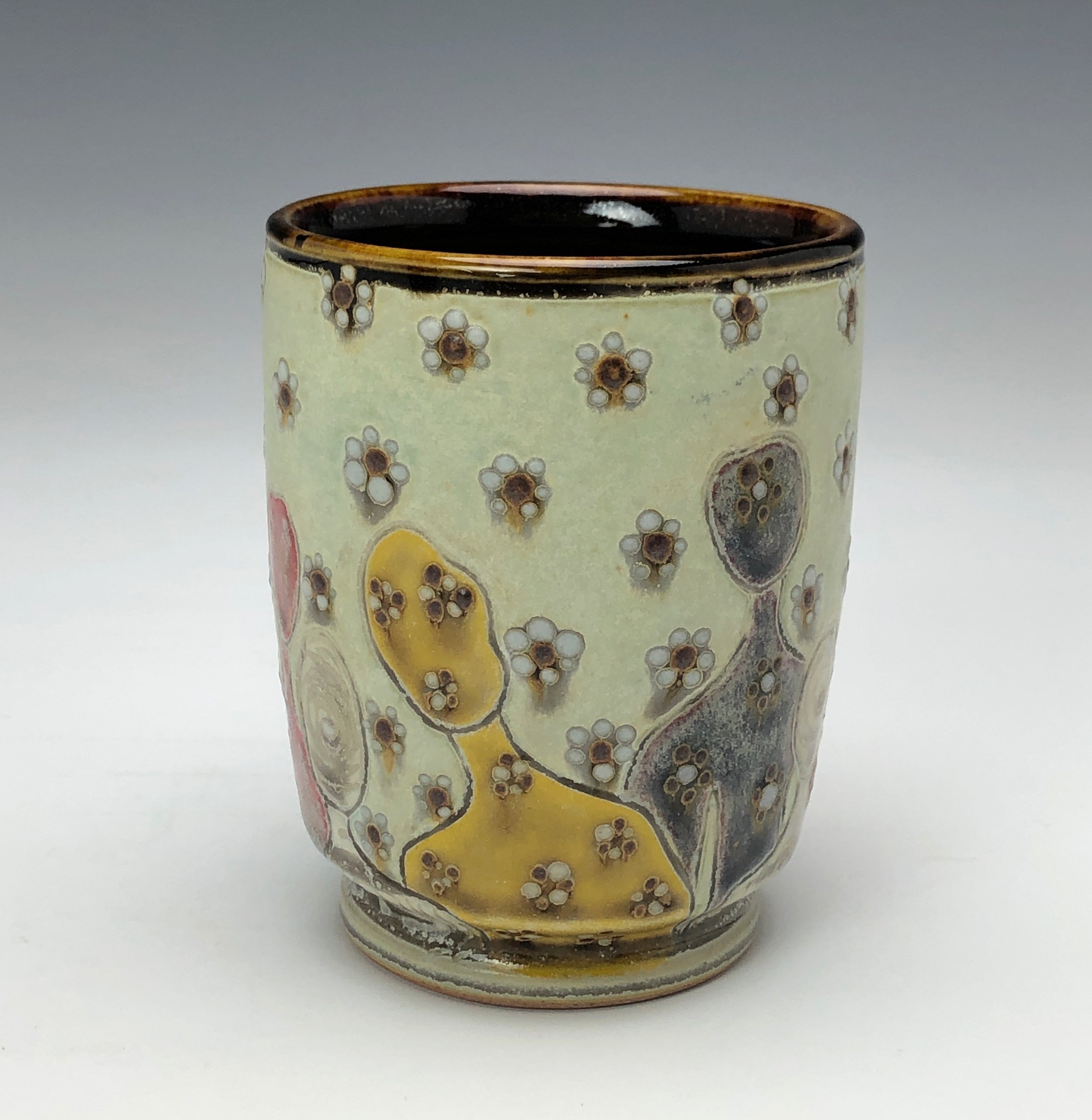  Samantha Henneke, Bulldog Pottery, Seagrove, North Carolina  Yunomi 6- Casual drinking cup made from a smooth white porcelaneous clay body. Figurative decoration with slip and glaze dot patterns. Translucent vellum glaze over various underglaze colo