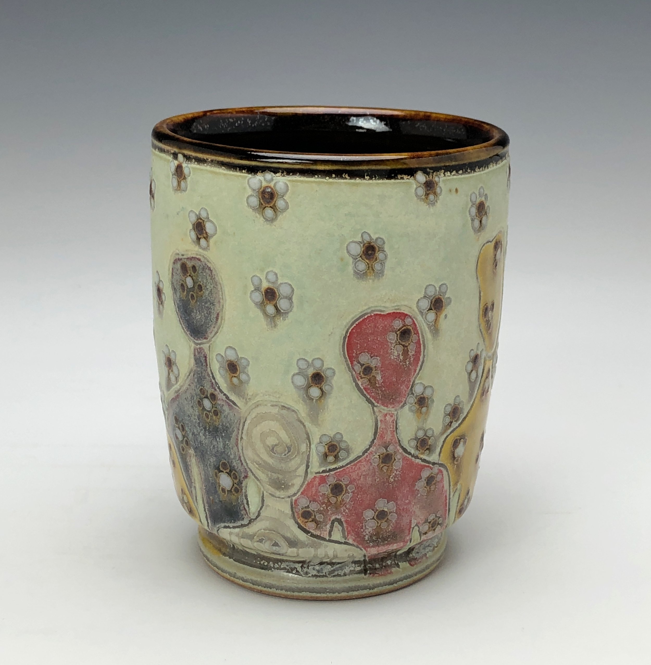  Samantha Henneke, Bulldog Pottery, Seagrove, North Carolina  Yunomi 6- Casual drinking cup made from a smooth white porcelaneous clay body. Figurative decoration with slip and glaze dot patterns. Translucent vellum glaze over various underglaze colo