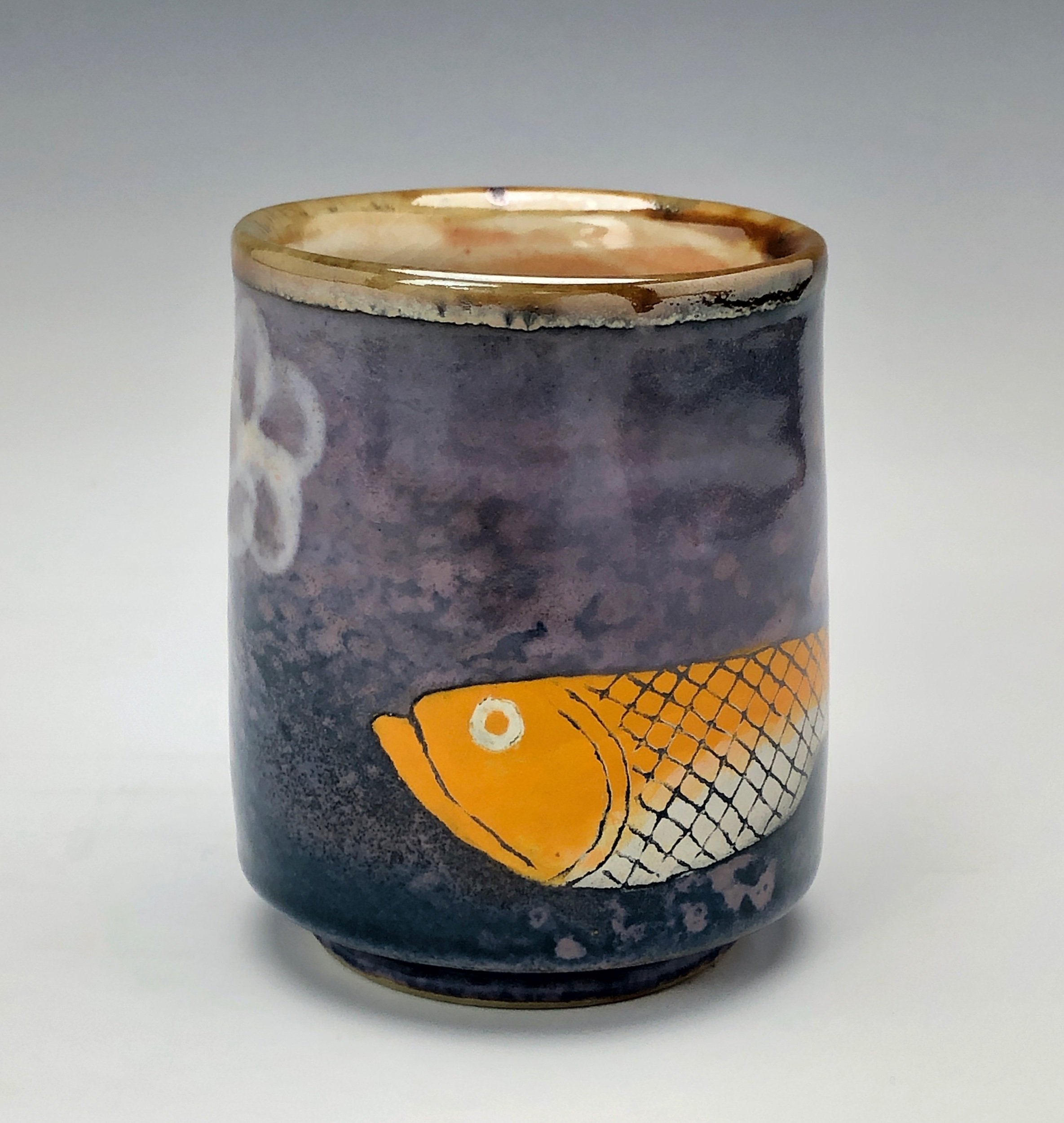  Bruce Gholson, Bulldog Pottery, Seagrove, North Carolina  Yunomi 6- Casual drinking cup made from porcelain. This cup is glazed with a lavender blue shino with a drawn fish in orange over glaze. 