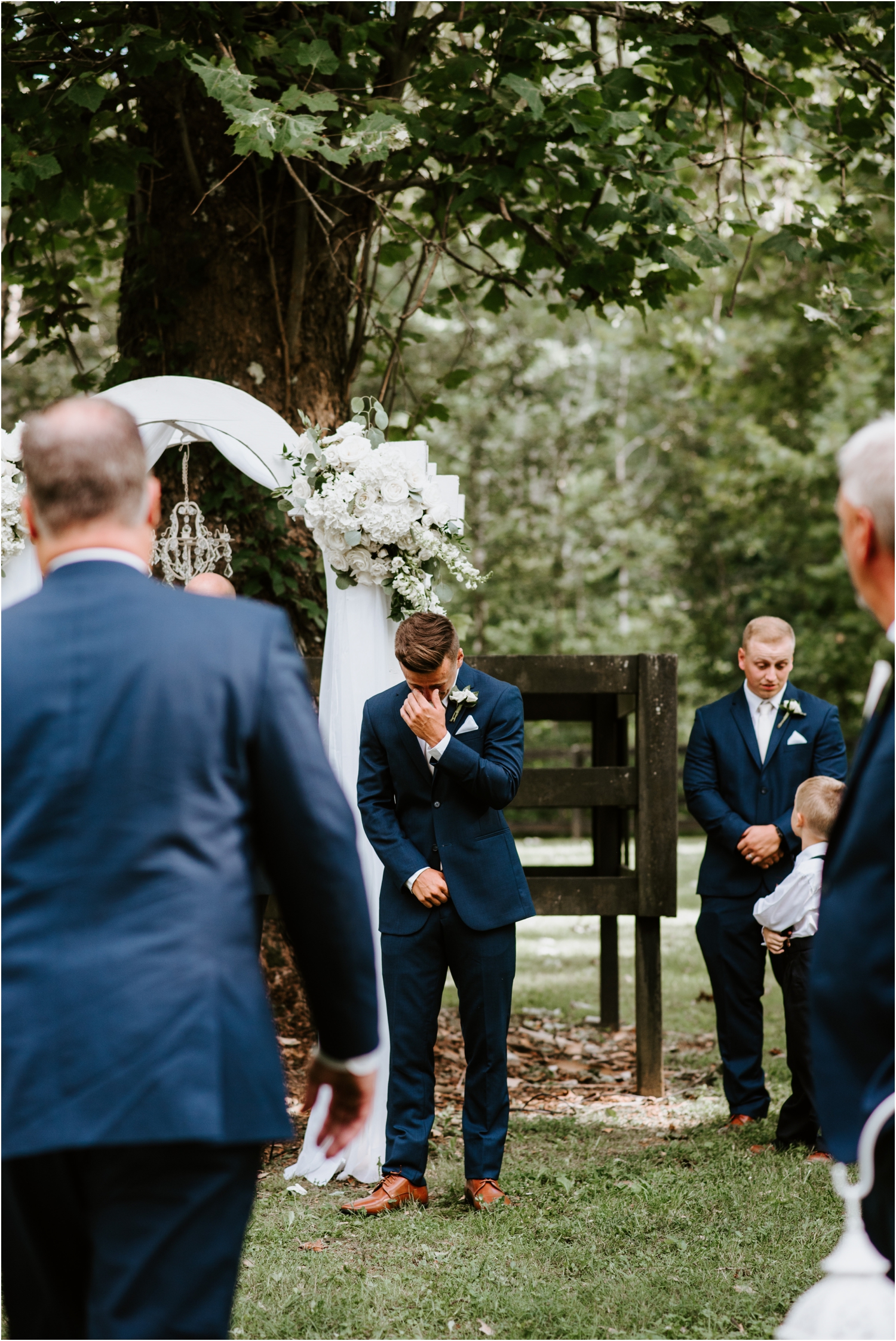 groom crying when bride walks down the aisle navy suit