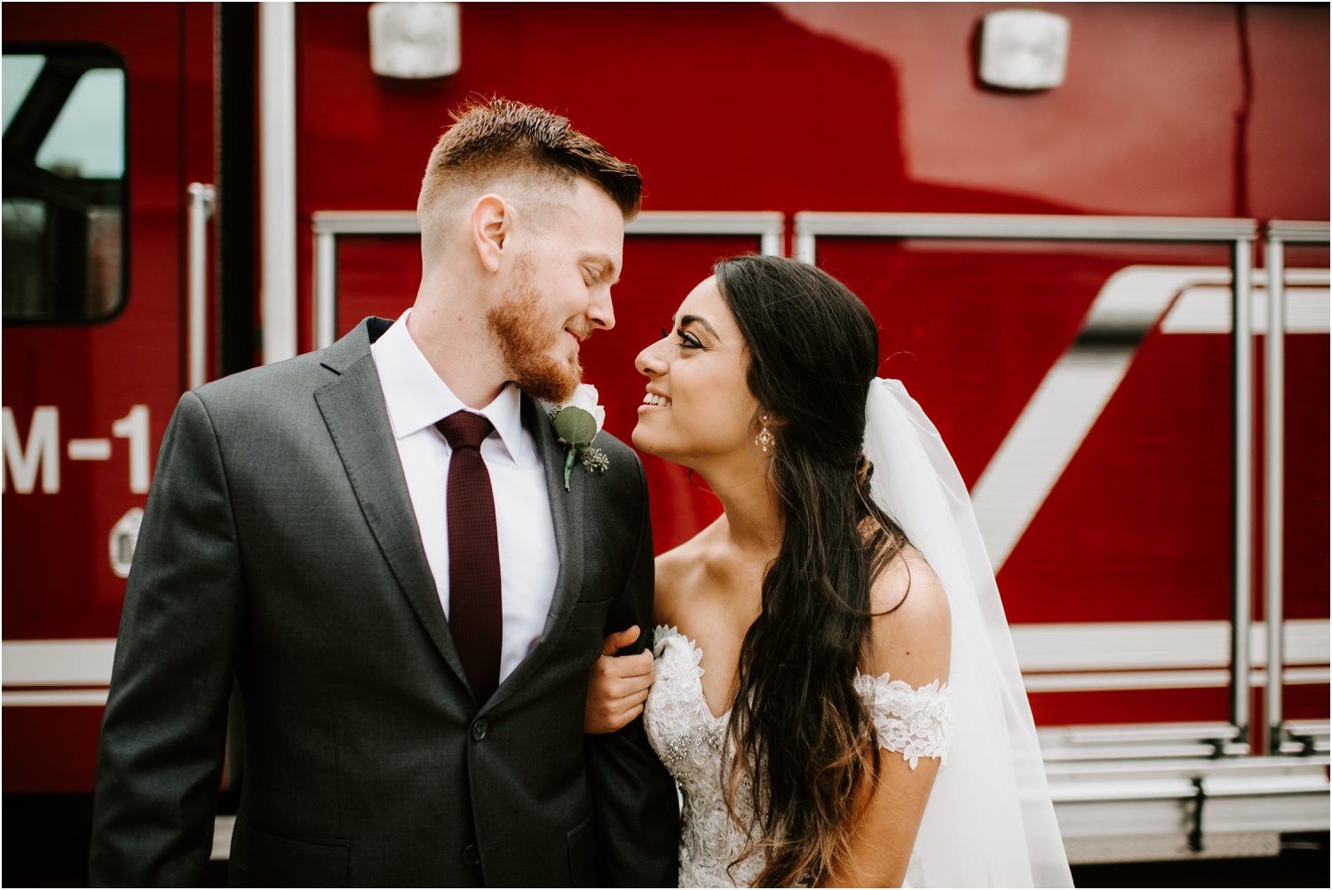 bride and groom in front of red fire truck