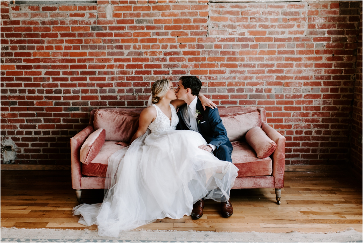 bride and groom kissing on velvet couch