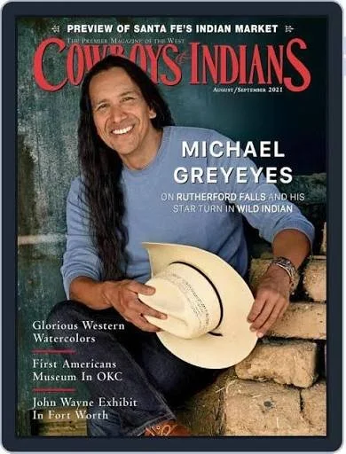 The cover of Cowboys & Indians magazine features Michael Greyeyes smiling and sitting outdoors, holding a beige cowboy hat.