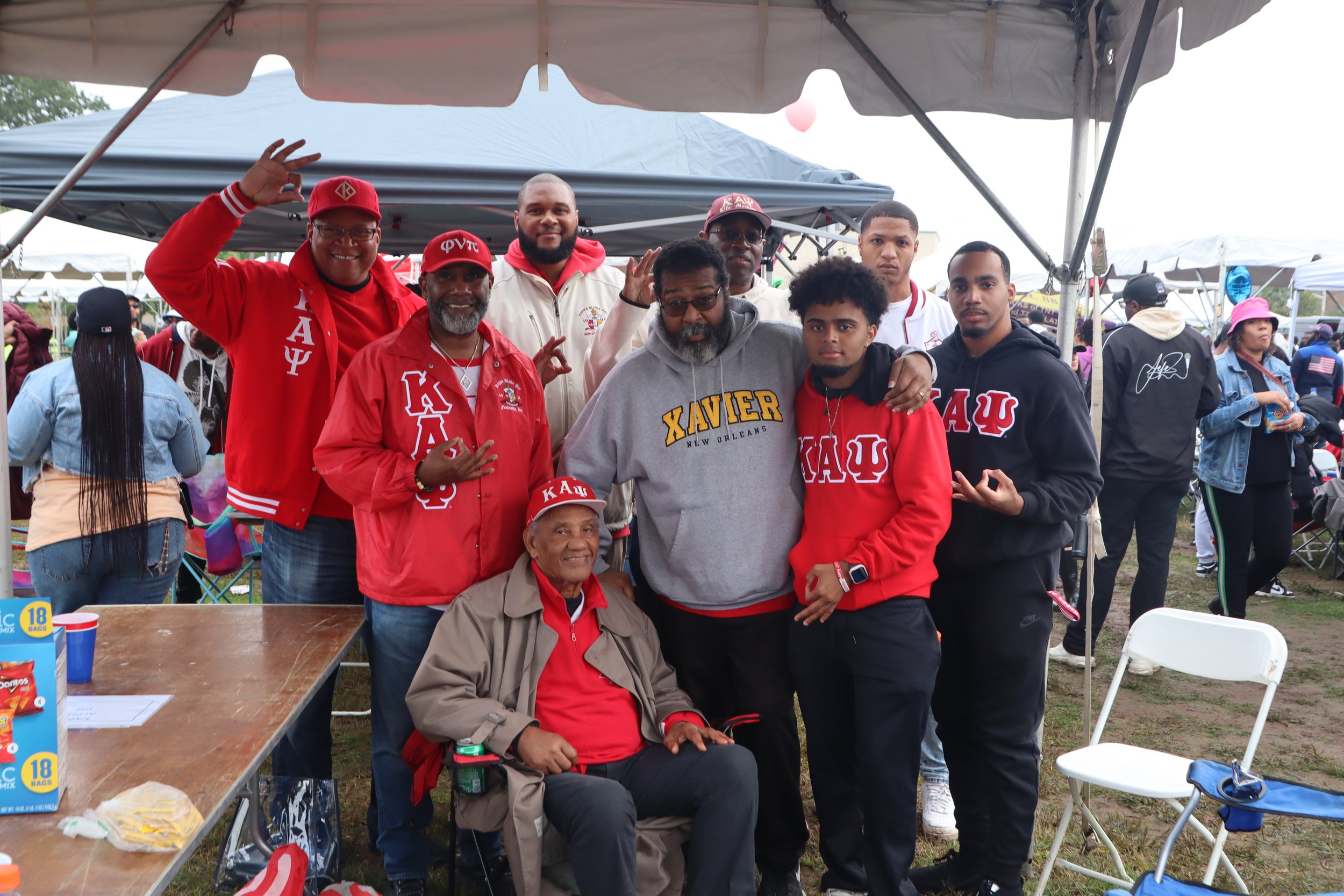 Brothers taking a group photo at the tailgate