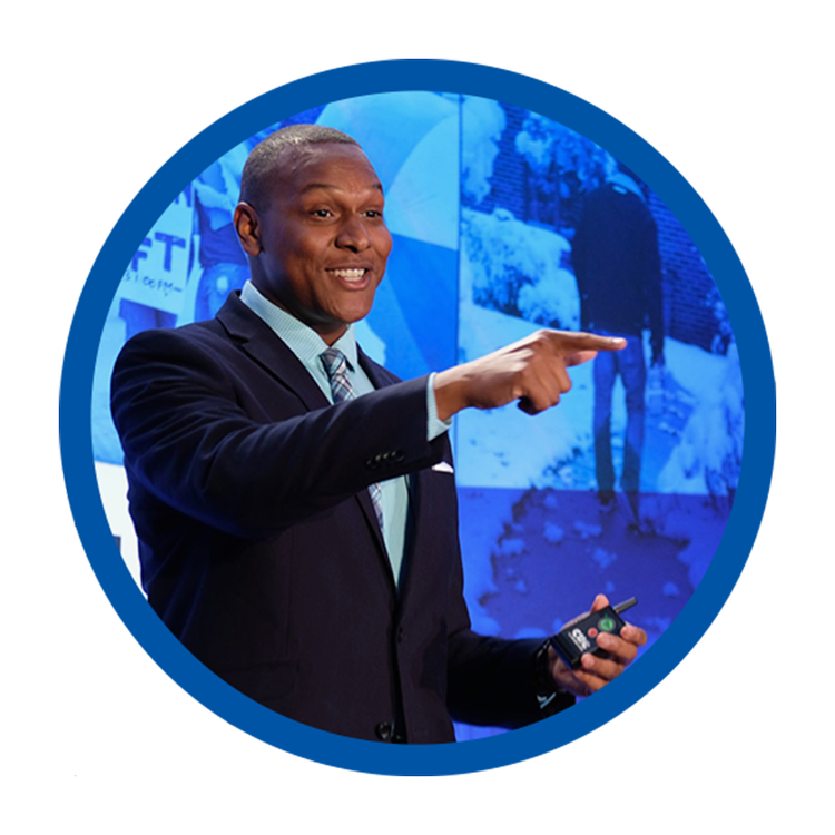 Stephen Rowe pointing toward the audience during a keynote presentation