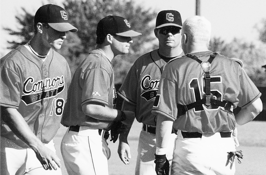 Coach Keith huddles with members of the Cowboys baseball team, 2000.