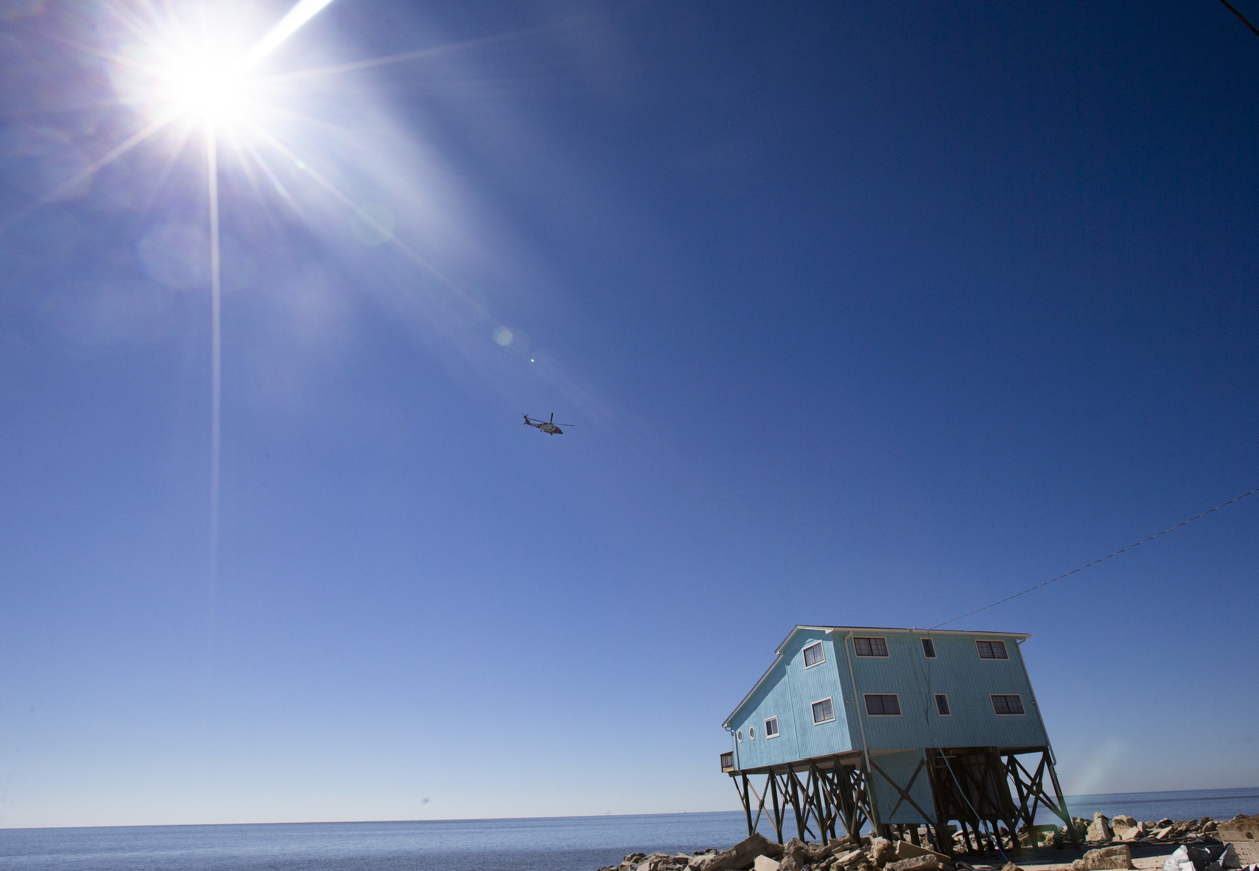 A Coast Guard helicopter flies over Alligator Drive in Alligator Point on October 12, 2018. A large portion of Alligator Drive was destroyed by Hurricane Michael leaving residents unable to drive to their homes.