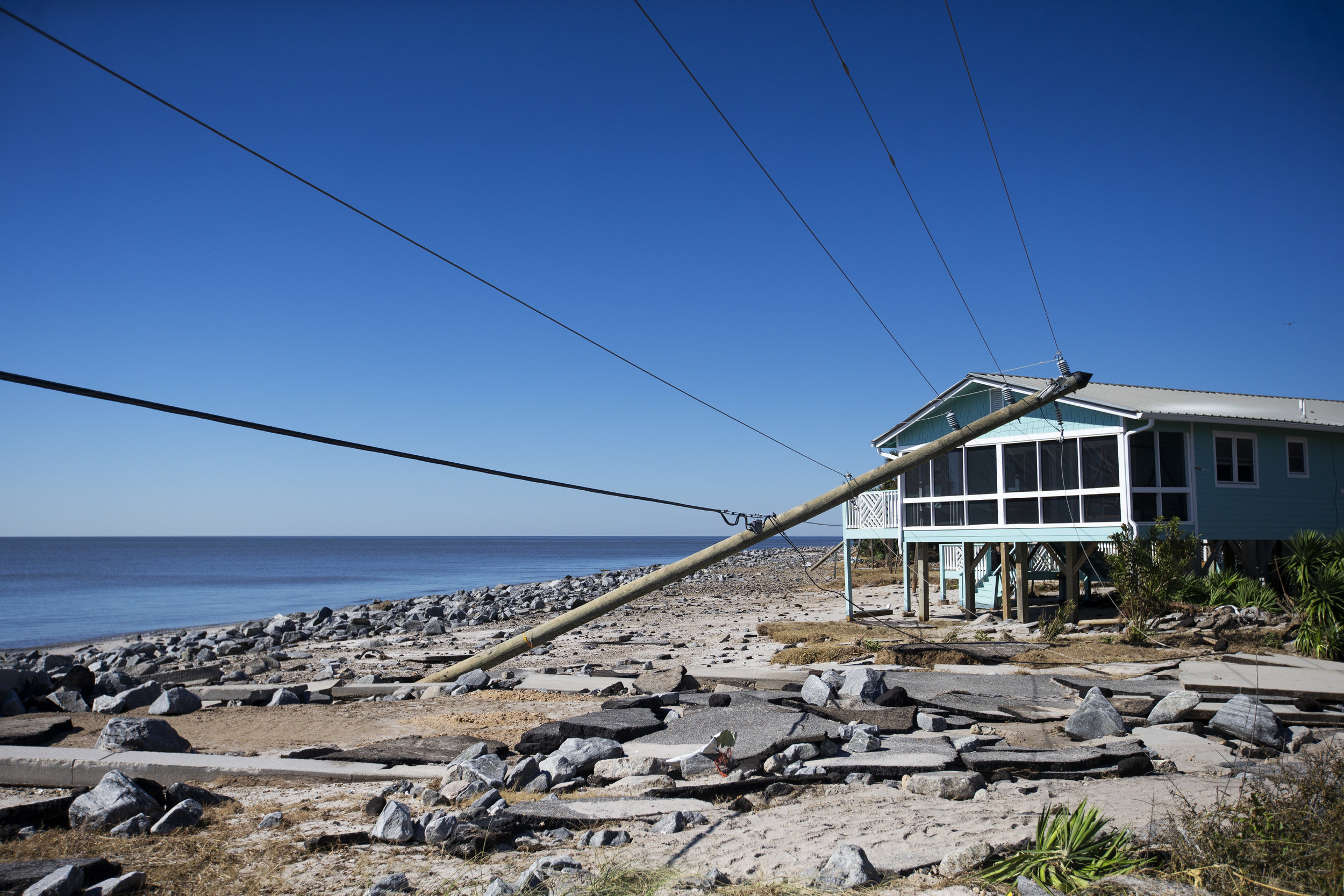 Downed powerlines lean into homes on Alligator Drive in Alligator Point on October 12, 2018.