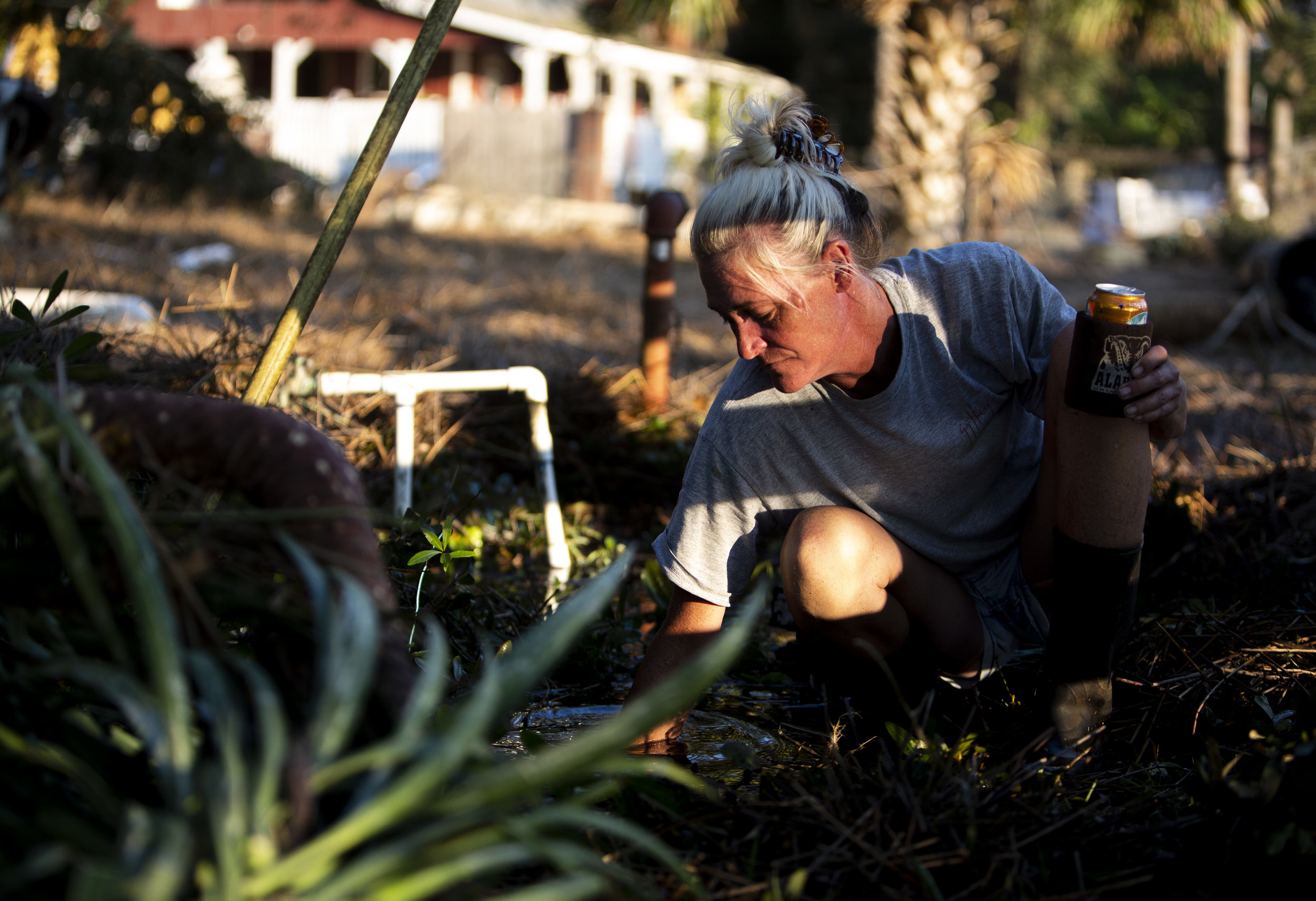 Lorie Spears, 46, searches through two-feet of water for a water main In Spring Creek on October 11, 2018 after Hurricane Michael hit the area. Spears' home was devastated by hurricane.
