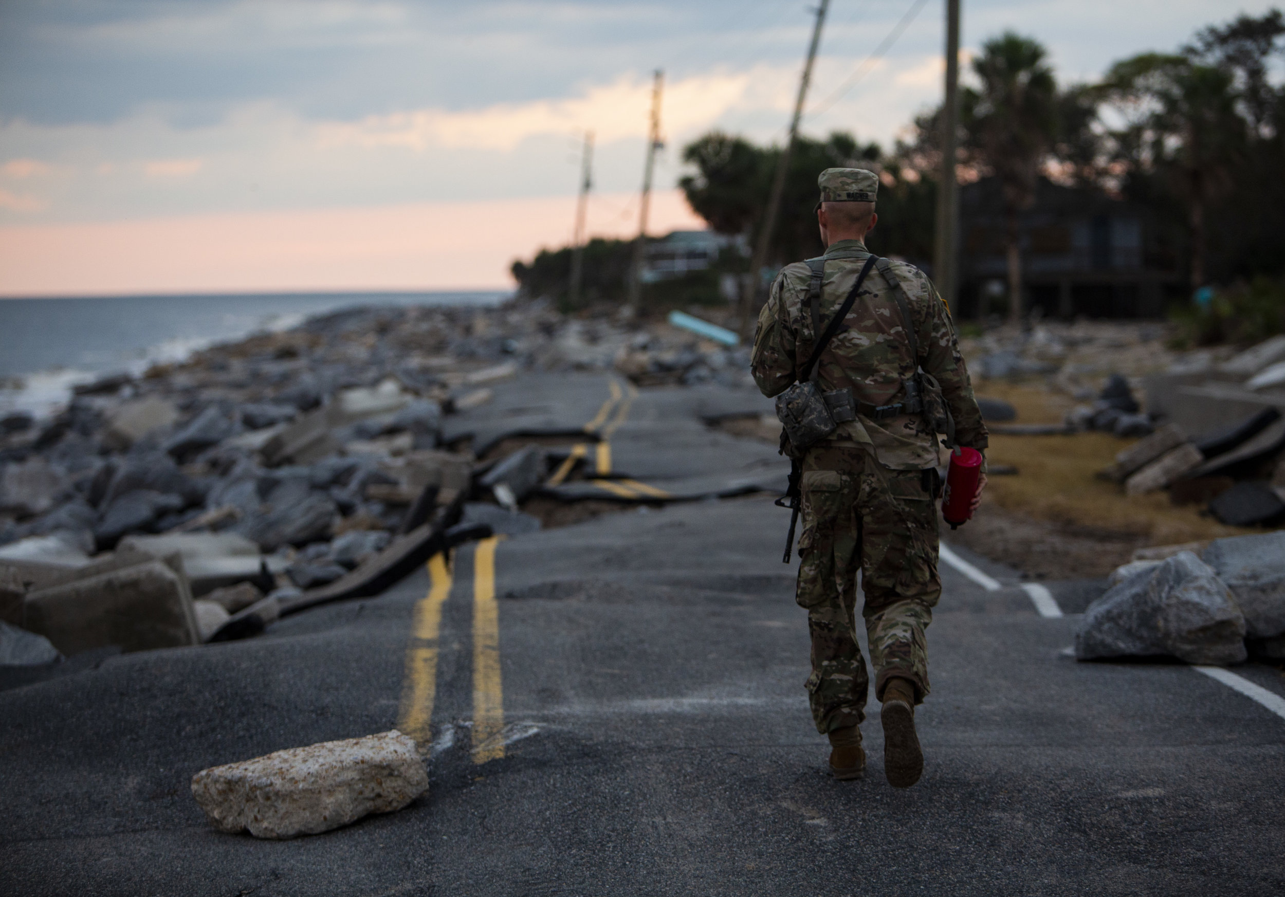  Florida Army National Guard Lt. Matt Wagner walks along what is left of Alligator Drive in Alligator Point on October 11, 2018, one day after Hurricane Michael hit the area. The National Guard descended on the area around 4 p.m.. 