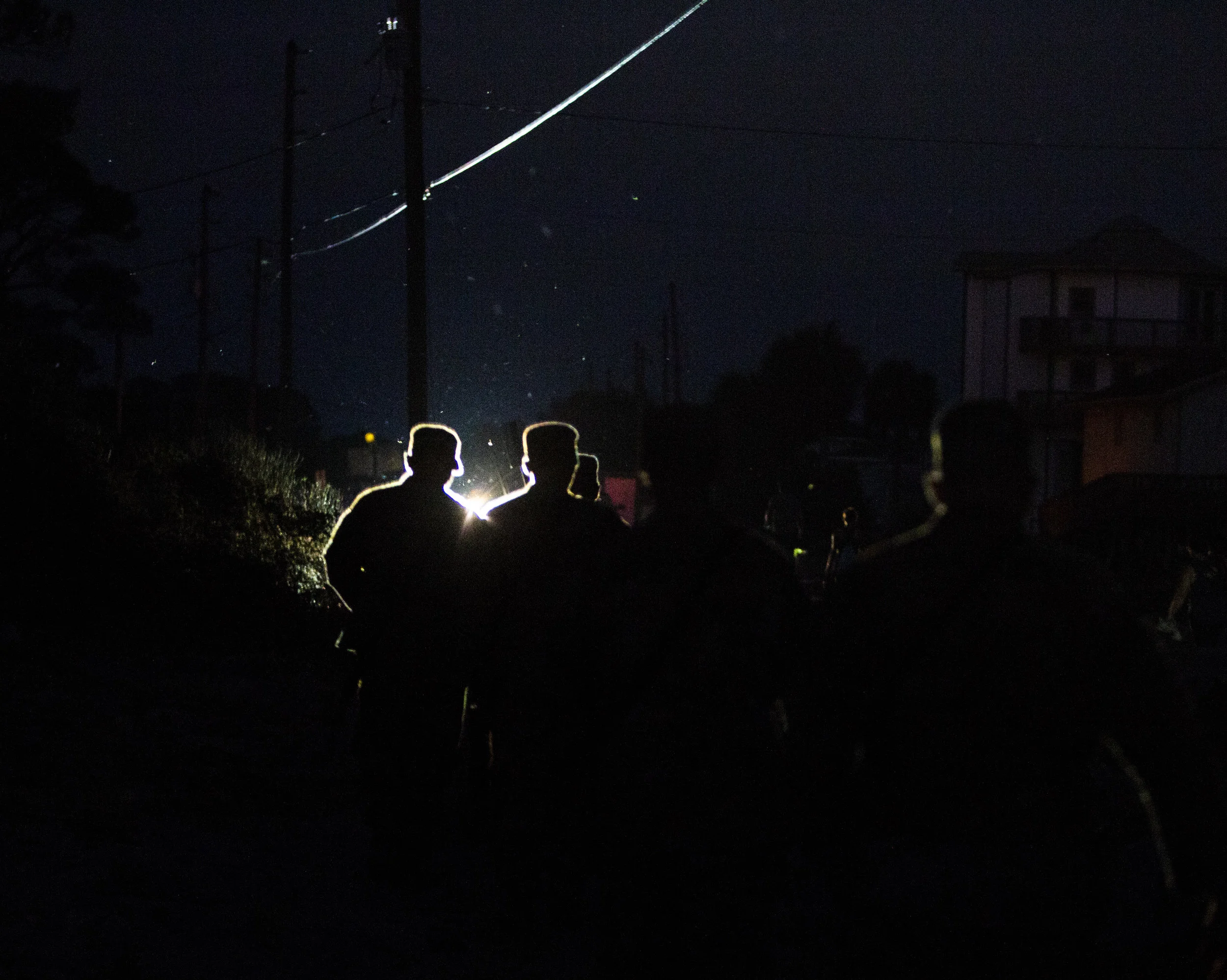 Members of Florida National Guard walk back to their trucks in the dark after patrolling Alligator Drive in Alligator Point on October 11, 2018, one day after Hurricane Michael hit the area. It may take weeks to restore power to parts of the Florida Panhandle.