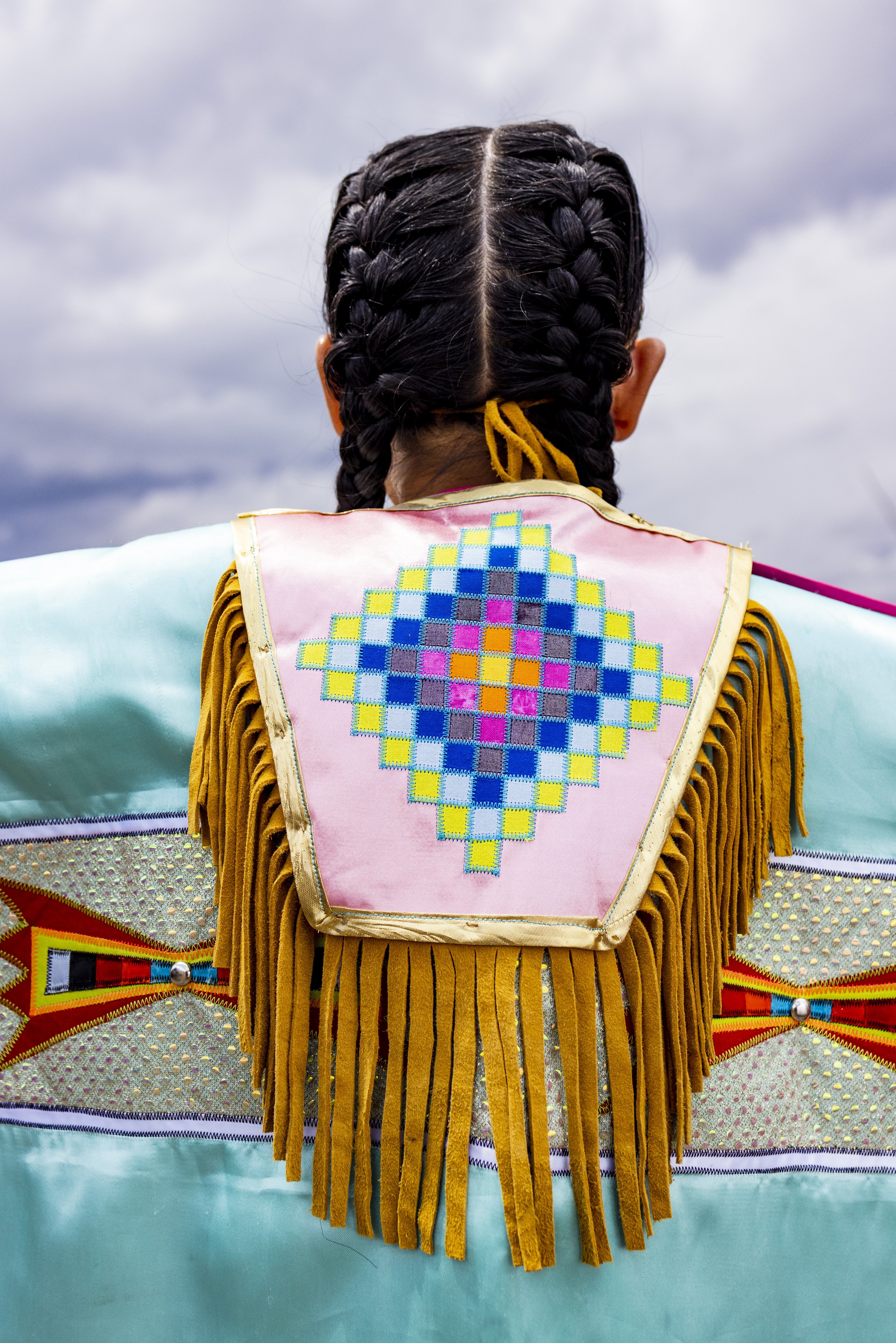   Harmony Kickingwoman showed off her favorite piece of regalia, a diamond back piece made by her father.  