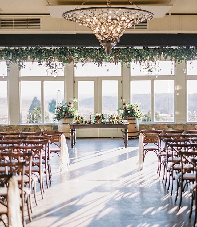 Winter indoor ceremony feels @stonetowerwinery || 🌿complete with the beautiful hanging greenery by: @hollychapple! 📷: @vickigrafton #martindowntheaisle