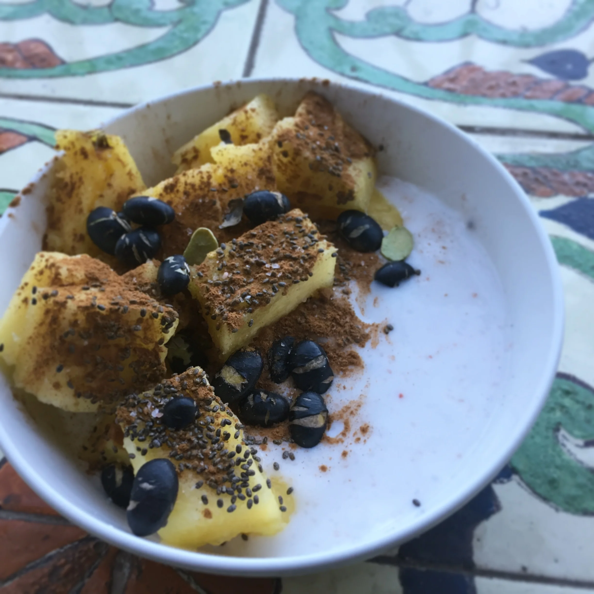 Coconut yogurt with fresh pineapple, chia seeds, roasted black edemame and cinnamon 