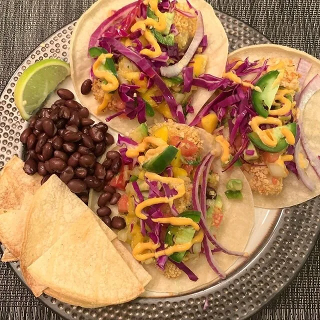Baked panko crusted cod fish tacos in corn tortillas with avocado-mango pico de gallo, red cabbage, sliced jalape&ntilde;o, red onion, sriracha mayo. Side of black beans and homemade corn tortilla chips.