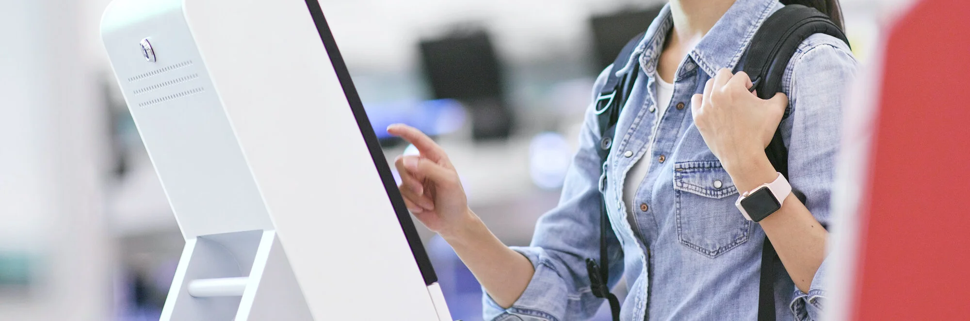 woman-using-selfie-check-in-machine-in-the-airport-MJSPNSL.jpg