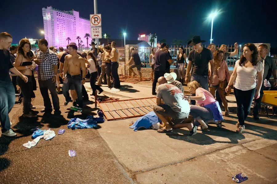 People tend to the wounded outside the Route 91 Harvest Country music festival grounds after an apparent shooting on October 1, 2017 in Las Vegas, Nevada. There are reports of an active shooter around the Mandalay Bay Resort and Casino. (Photo by David Becker/Getty Images) 