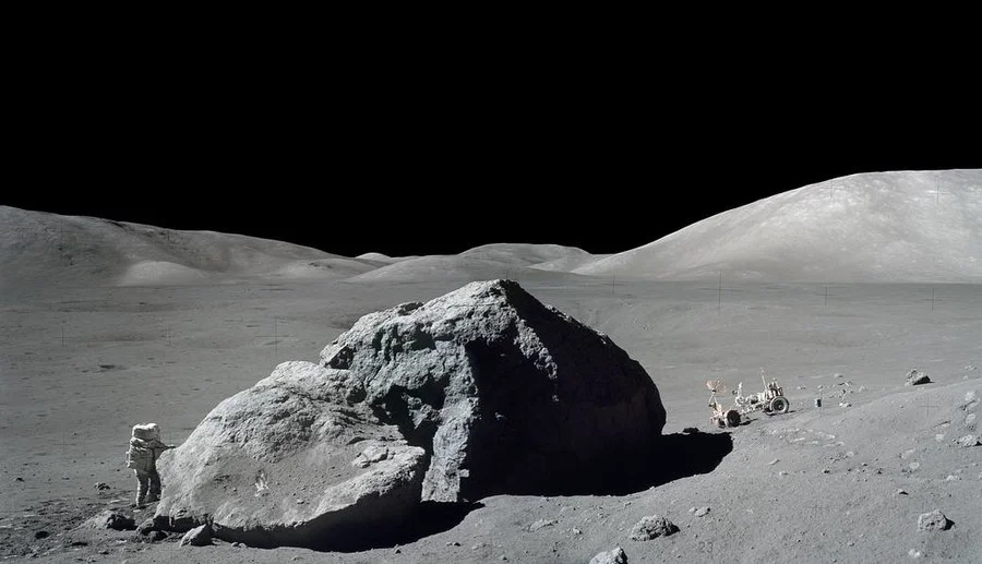 Schmitt is photographed standing next to a huge, split lunar boulder © NASA
