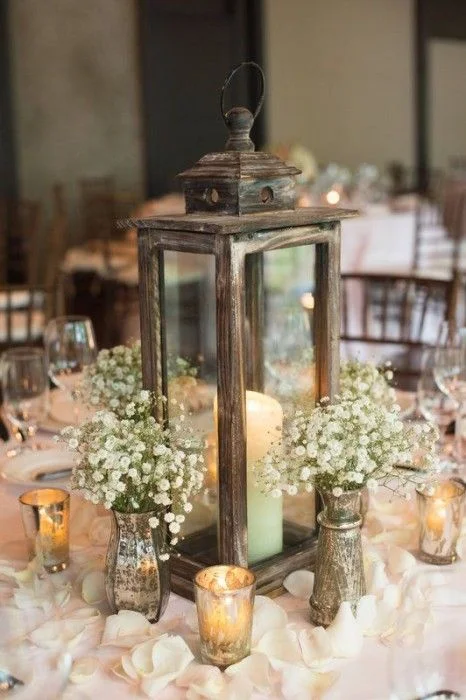 And here is my favorite. This beautiful winter wedding centerpiece combines rustic appeal with classic candles and subtle arrangements of flowers. 