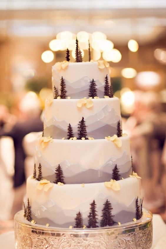 How about this magical winter wedding cake that incorporates the majesty of winter, snow-covered peaks with beautiful pine trees.