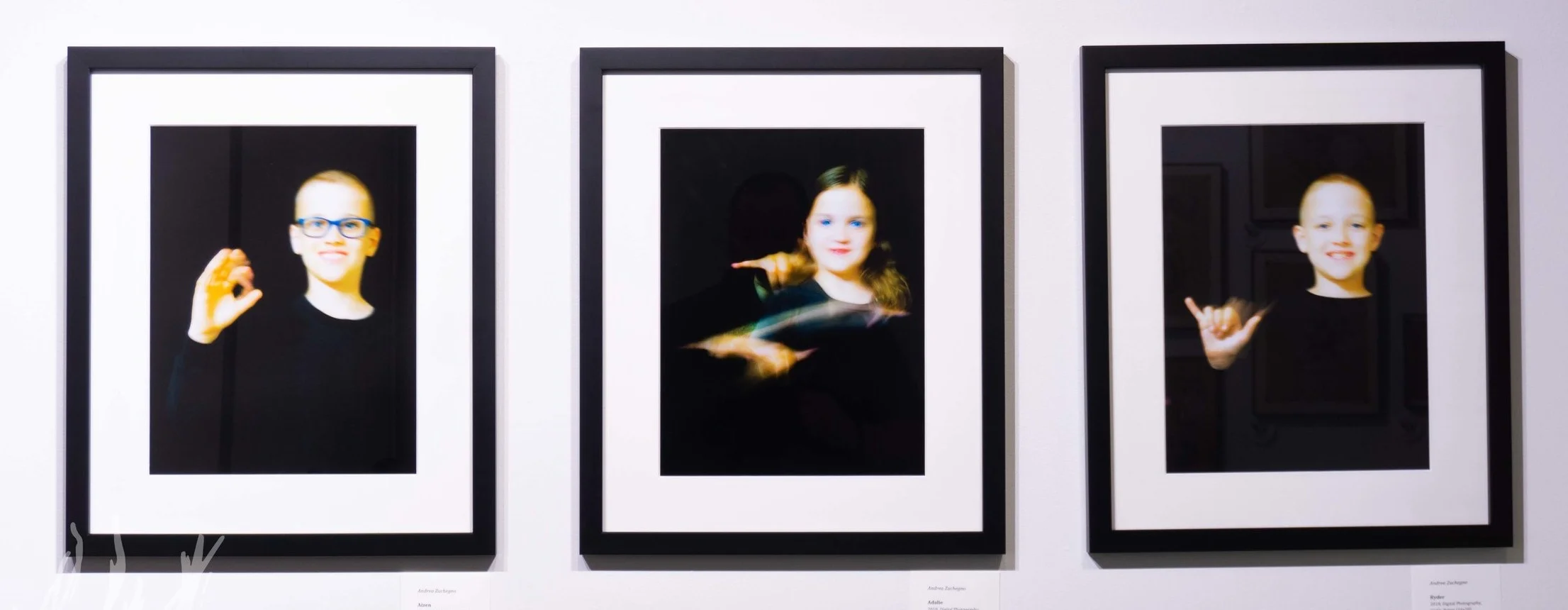 A photographic triptych by Andrea Zuchegno featuring her children’s name signs.