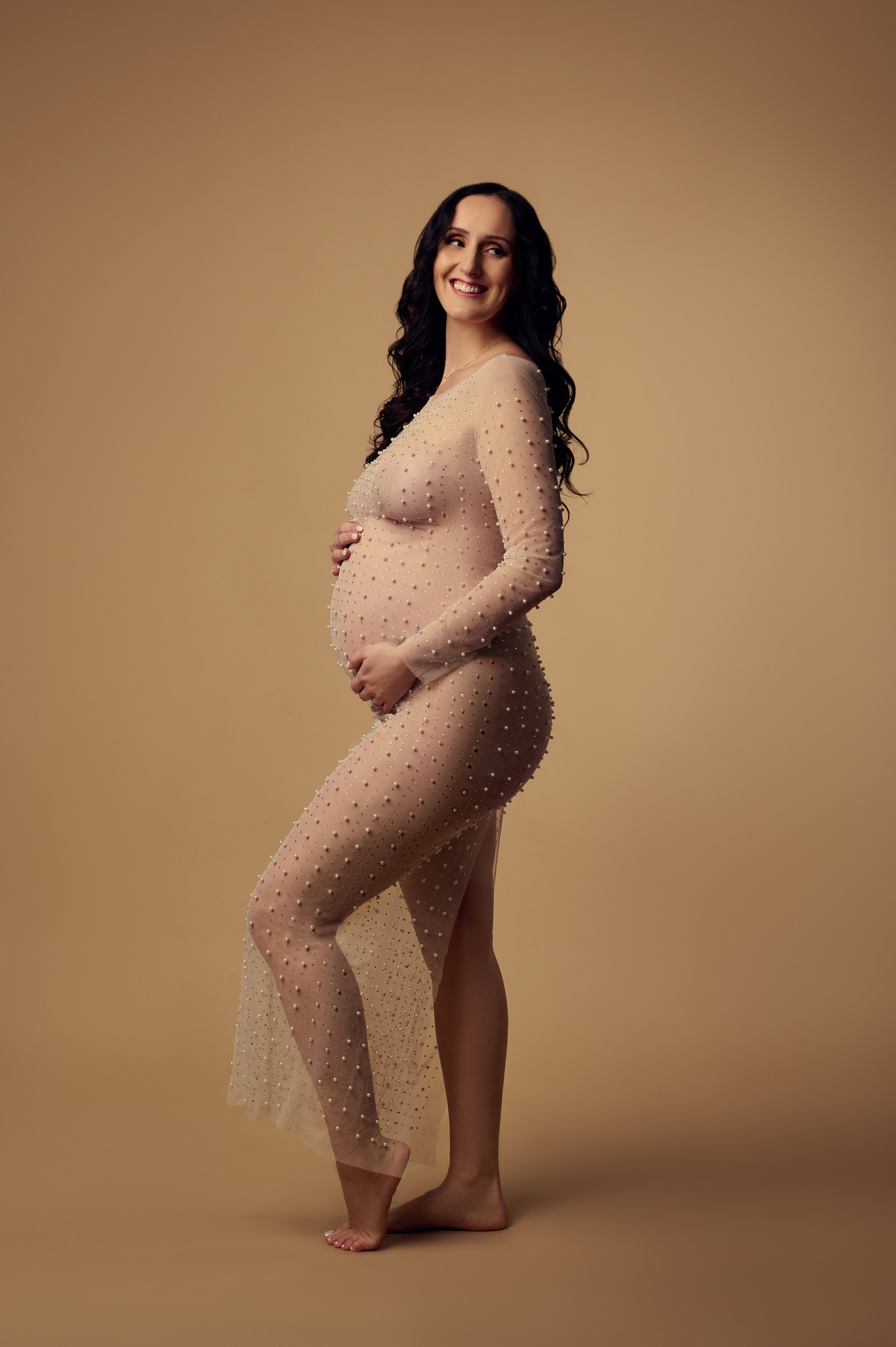 pregnant woman in pearl gown with tan background.jpg
