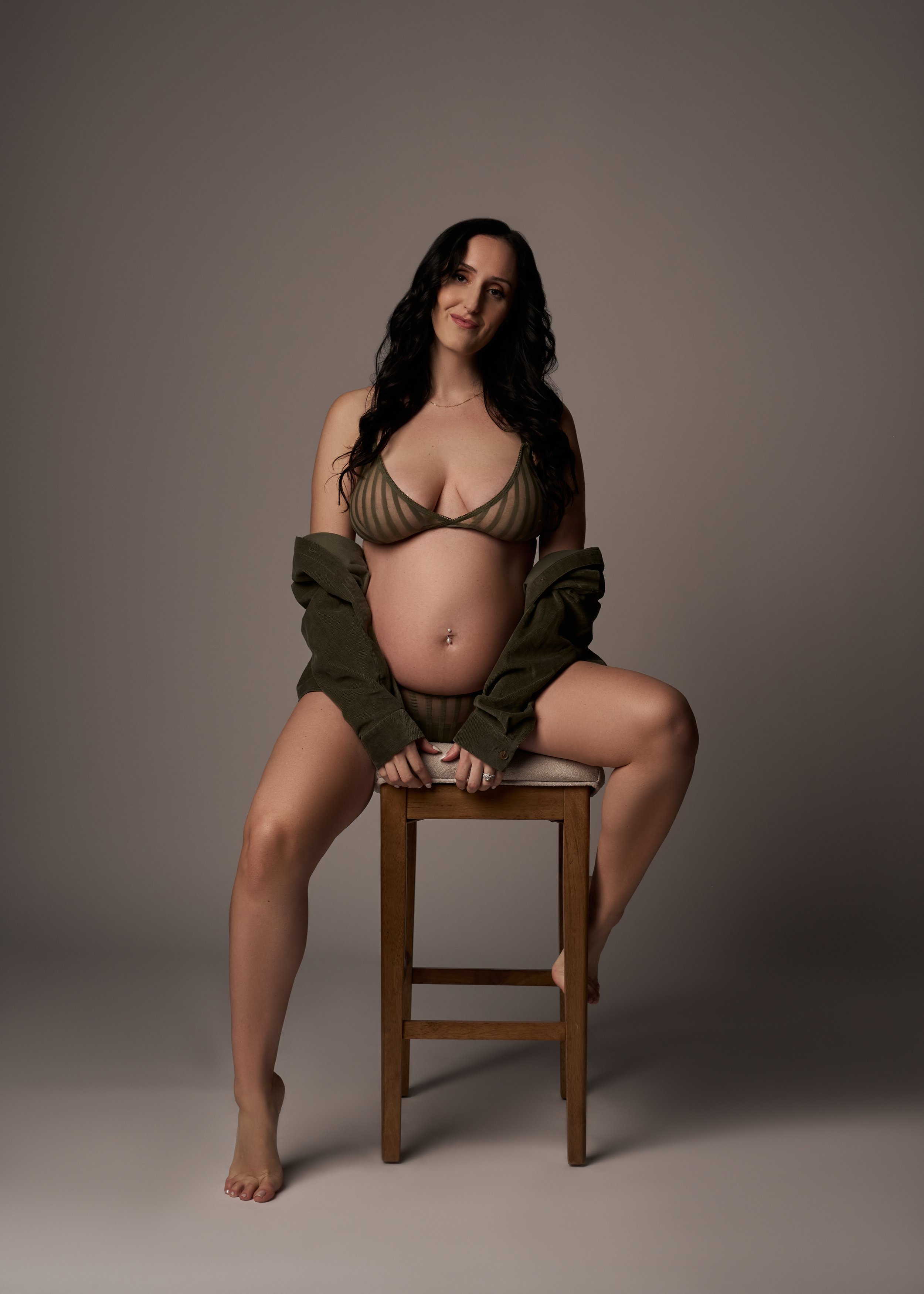 pregnant woman sitting on stool in green lingerie.jpg