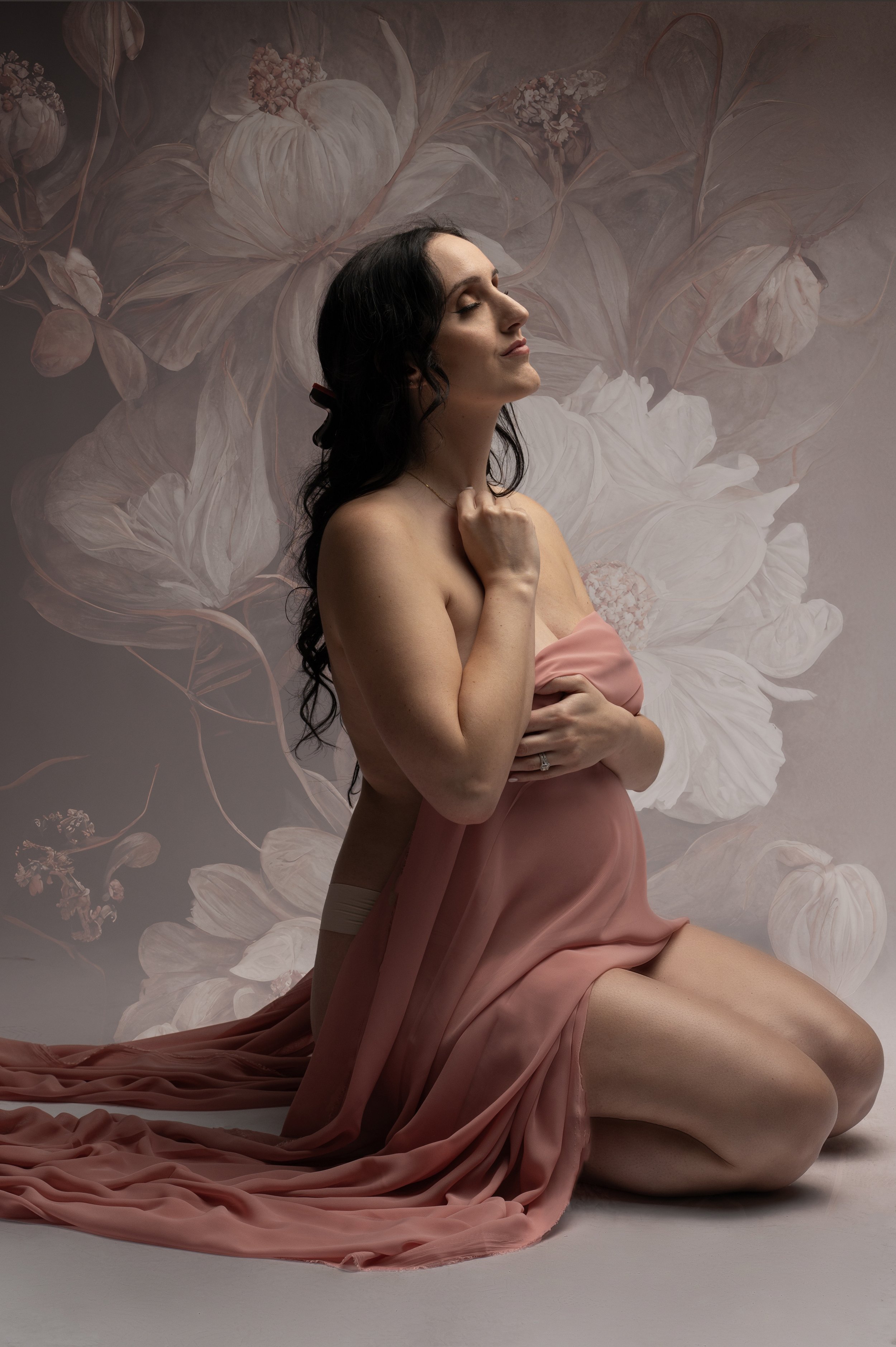 pregnant-woman-covered-in-silk-floral-background.jpg