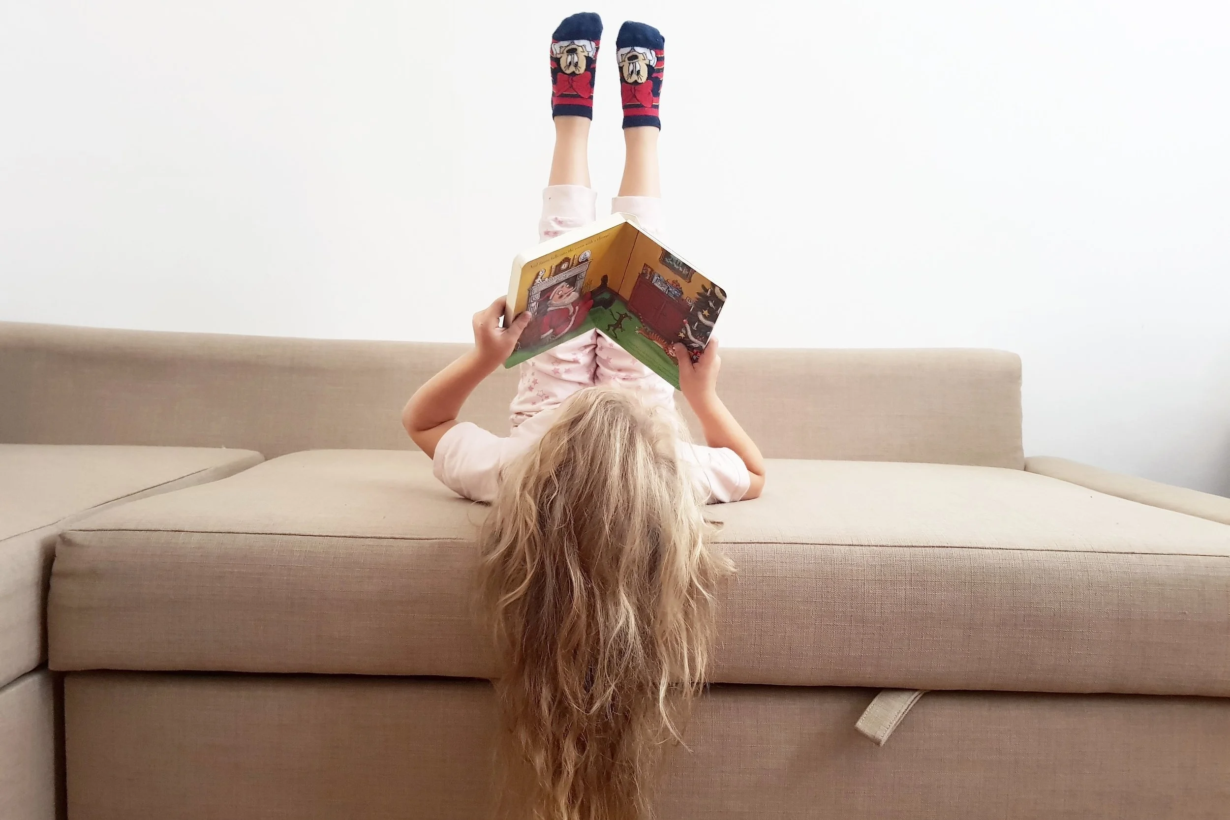 Reading Stick Man by Julia Donaldson on the sofa at home