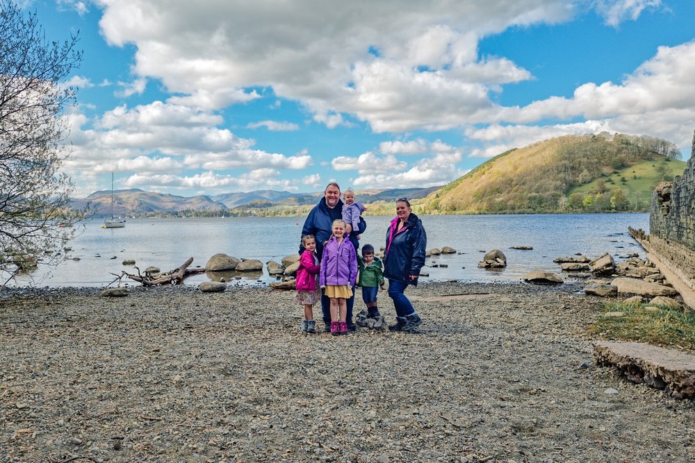 The Hassan family are stood on the lakeshore of Ullswater in 2022.