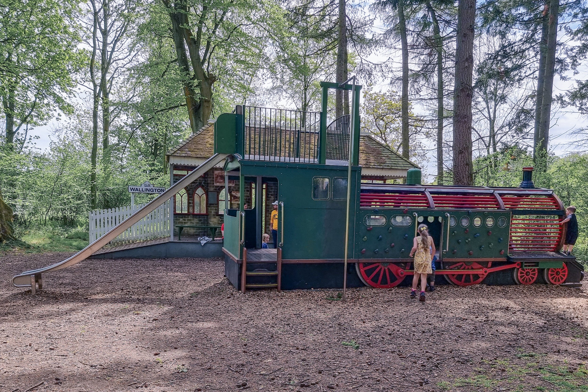 An image of the full view of the play train. It's a metal play frame in the shape of a train with a large slide on the back end.