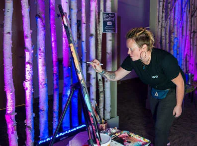 Artist Meg Rogers, curator for one of the pop-up galleries in Keene, paints at a Machina Arts event at The HIVE.