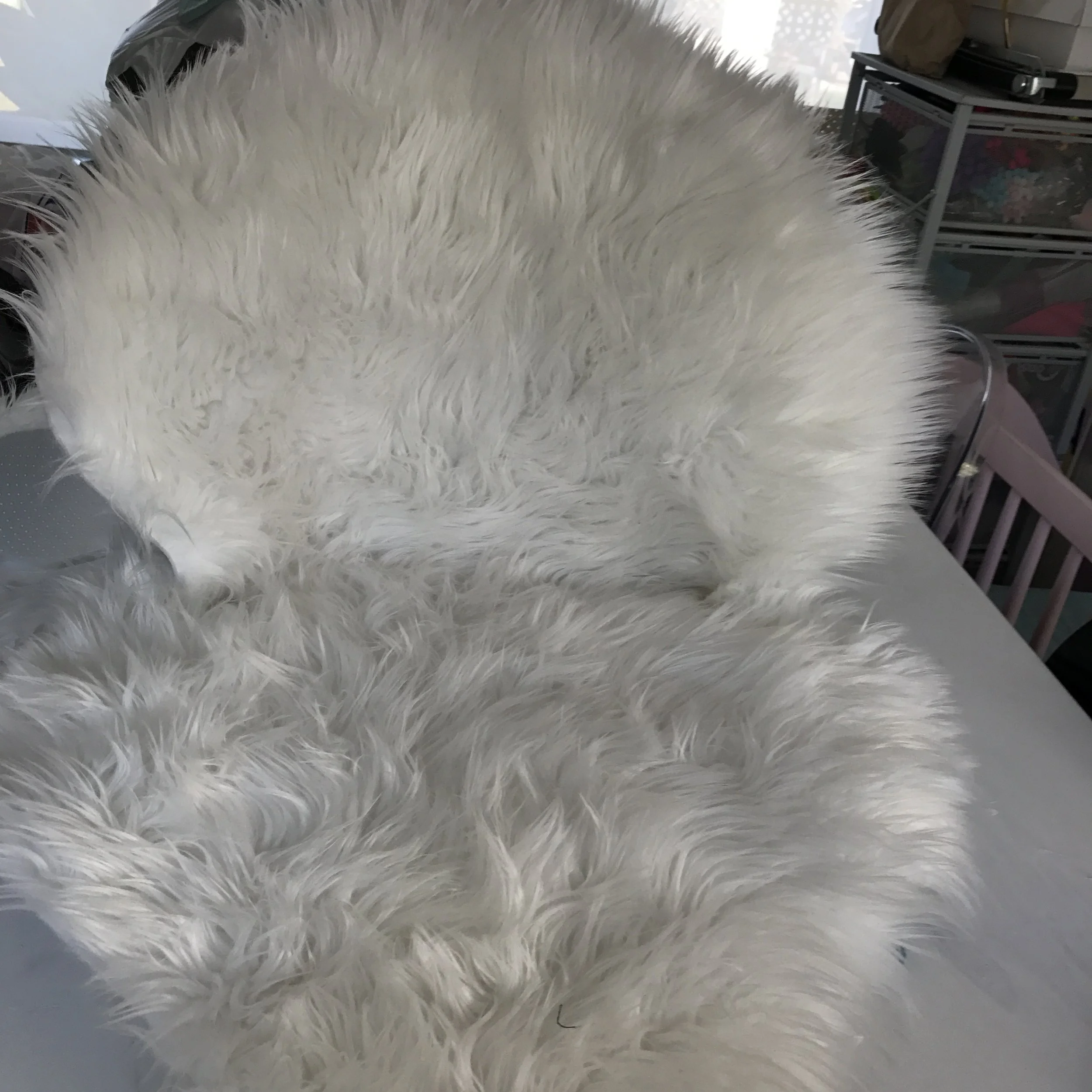 Flip the chair over, cut the second rug as you did the first, but to fit the front side of the chair. Hot glue to the front of the chair. To secure the two rugs, get a long needle and white cotton and sew both rugs together. If you are not a strong sewer, you can use more hot glue and trim rug excess. Once both side of the chair are covered, assemble as per Kmart instructions and VOILA!!!! A pottery Barn Kids fur chair for $87!