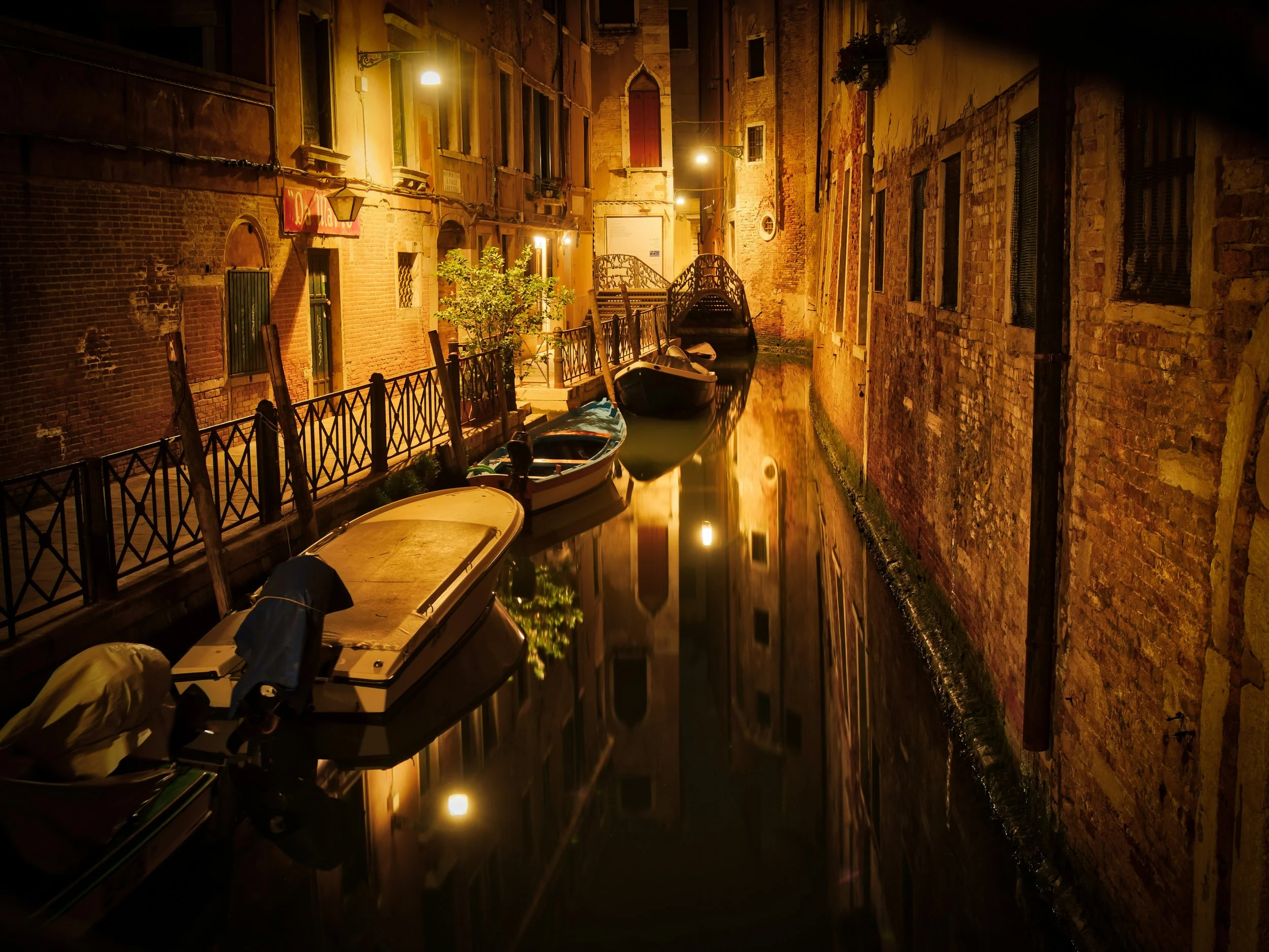 A streetlight-lit Venetian canal after dark.
