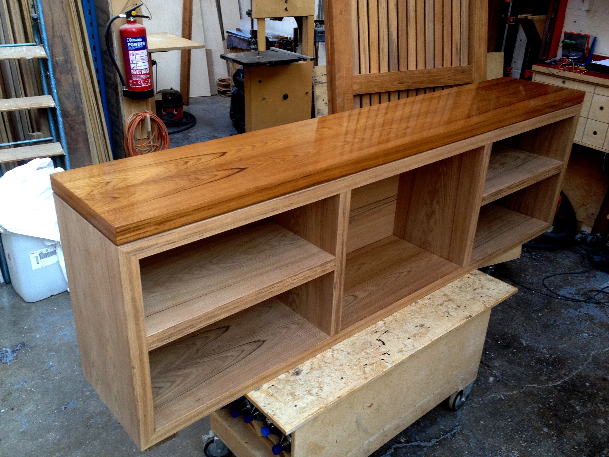 Solid teak sideboard cabinet with marine lacquered gloss top for the deck of a private yacht.